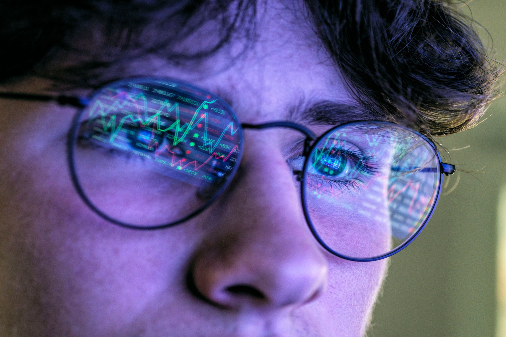 Young man viewing the performance of his online shares portfolio on his computer.