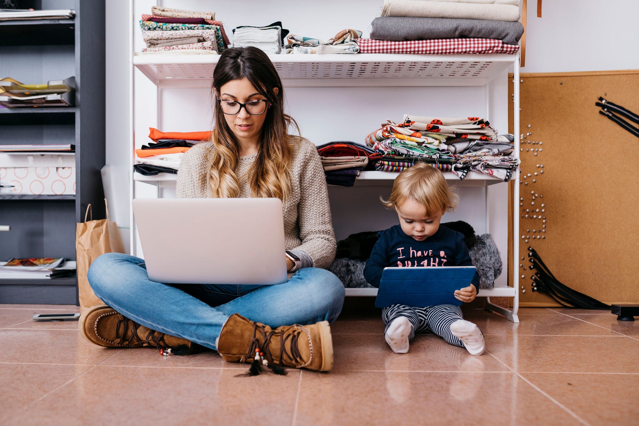 ey-mother-and-little-daughter-sitting-on-the-floor-at-home-using-laptop-and-tablet