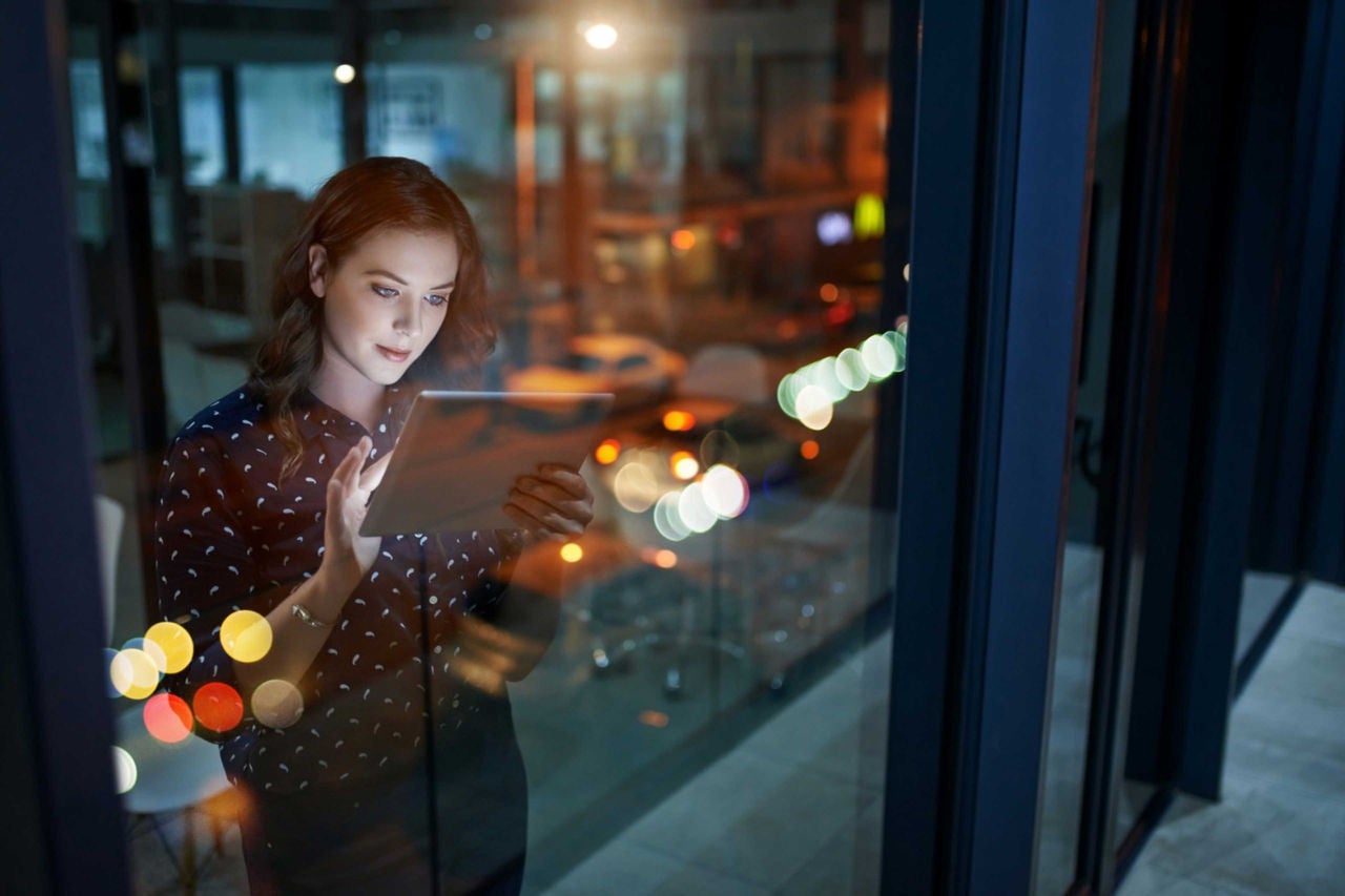 Business professional using a tablet near a window