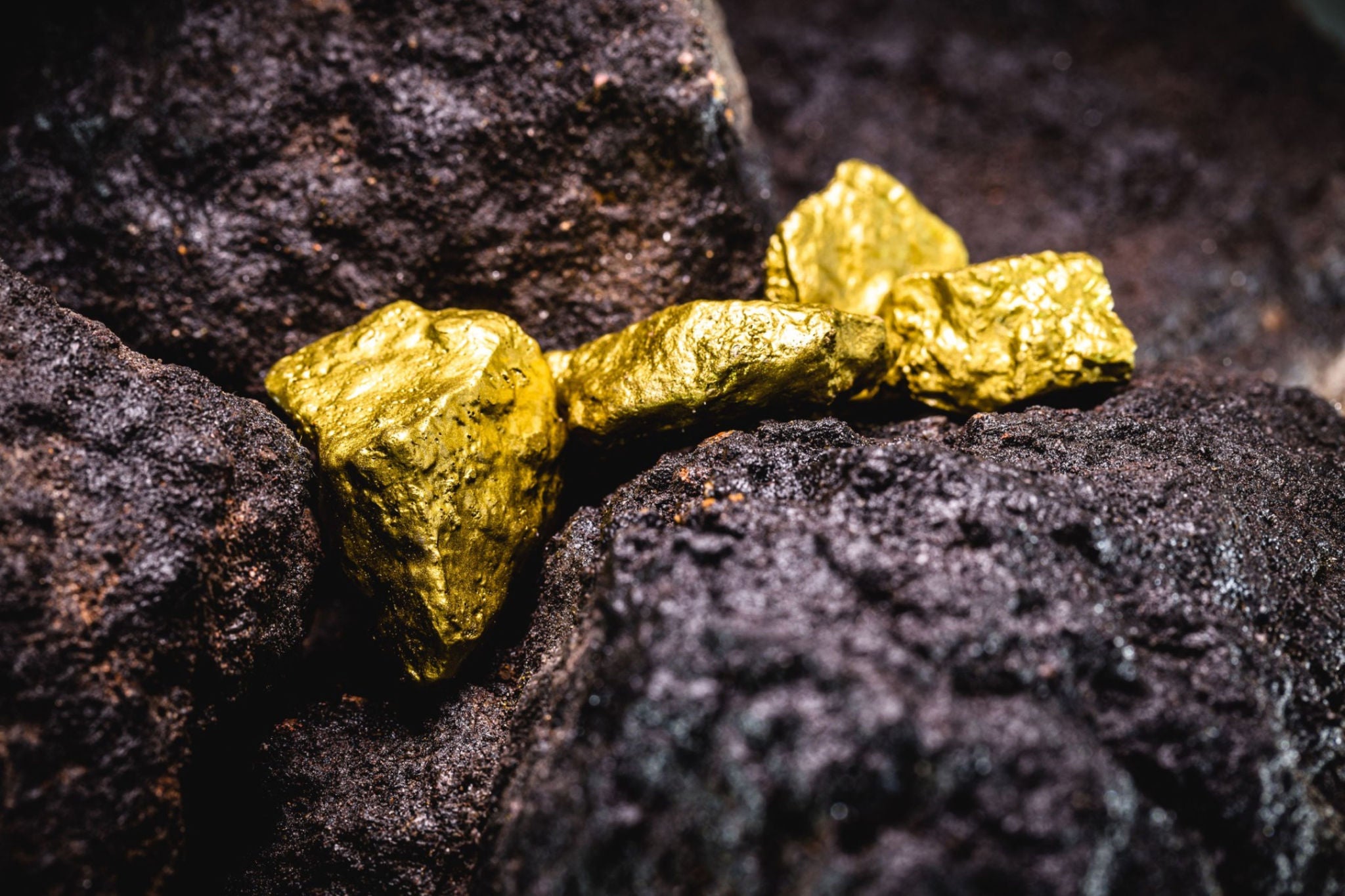 Primer plano de piedras de oro sobre rocas negras