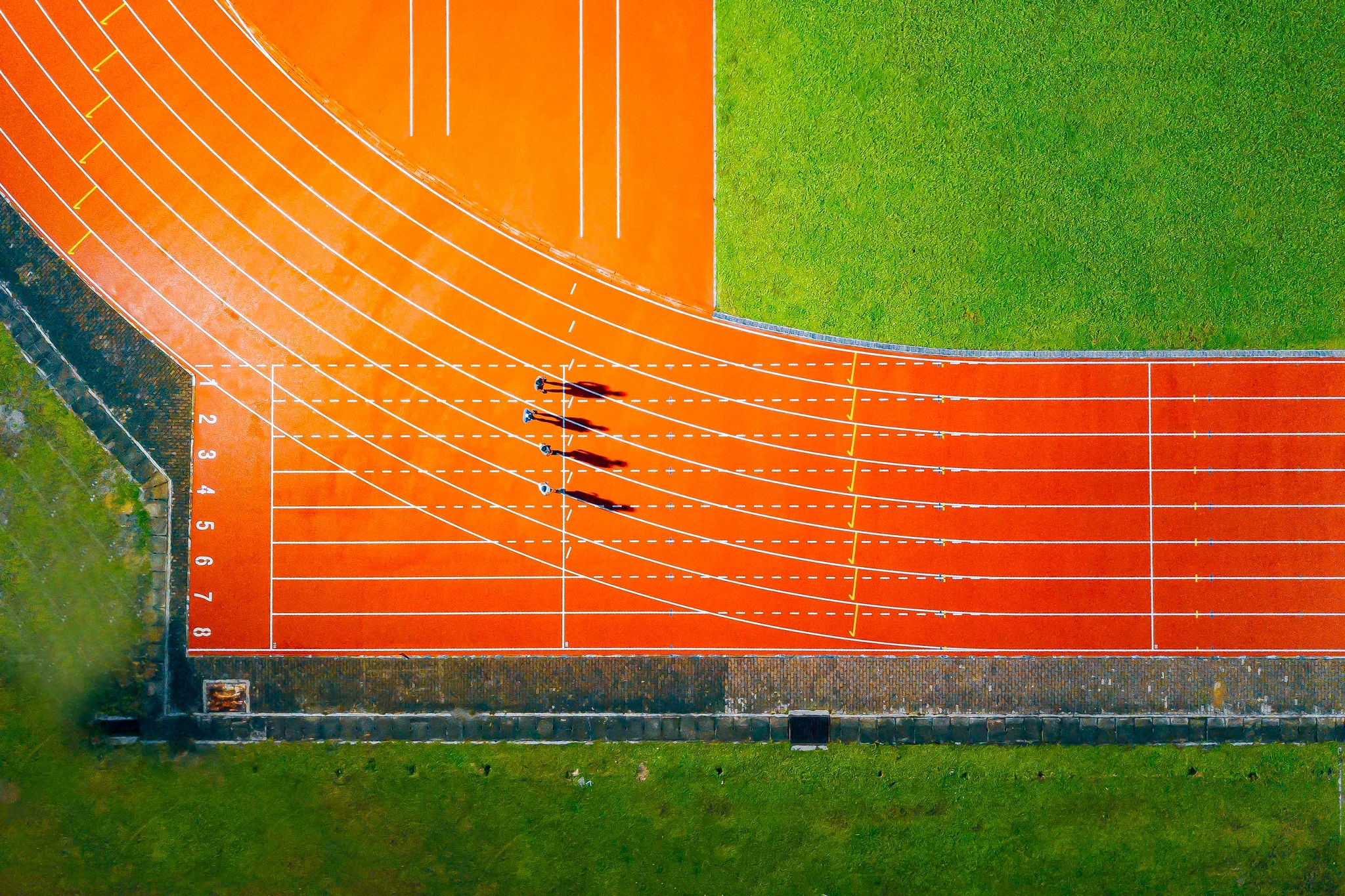 directly above drone point of view asian chinese male athlete running at men's track rainy late evening in stadium