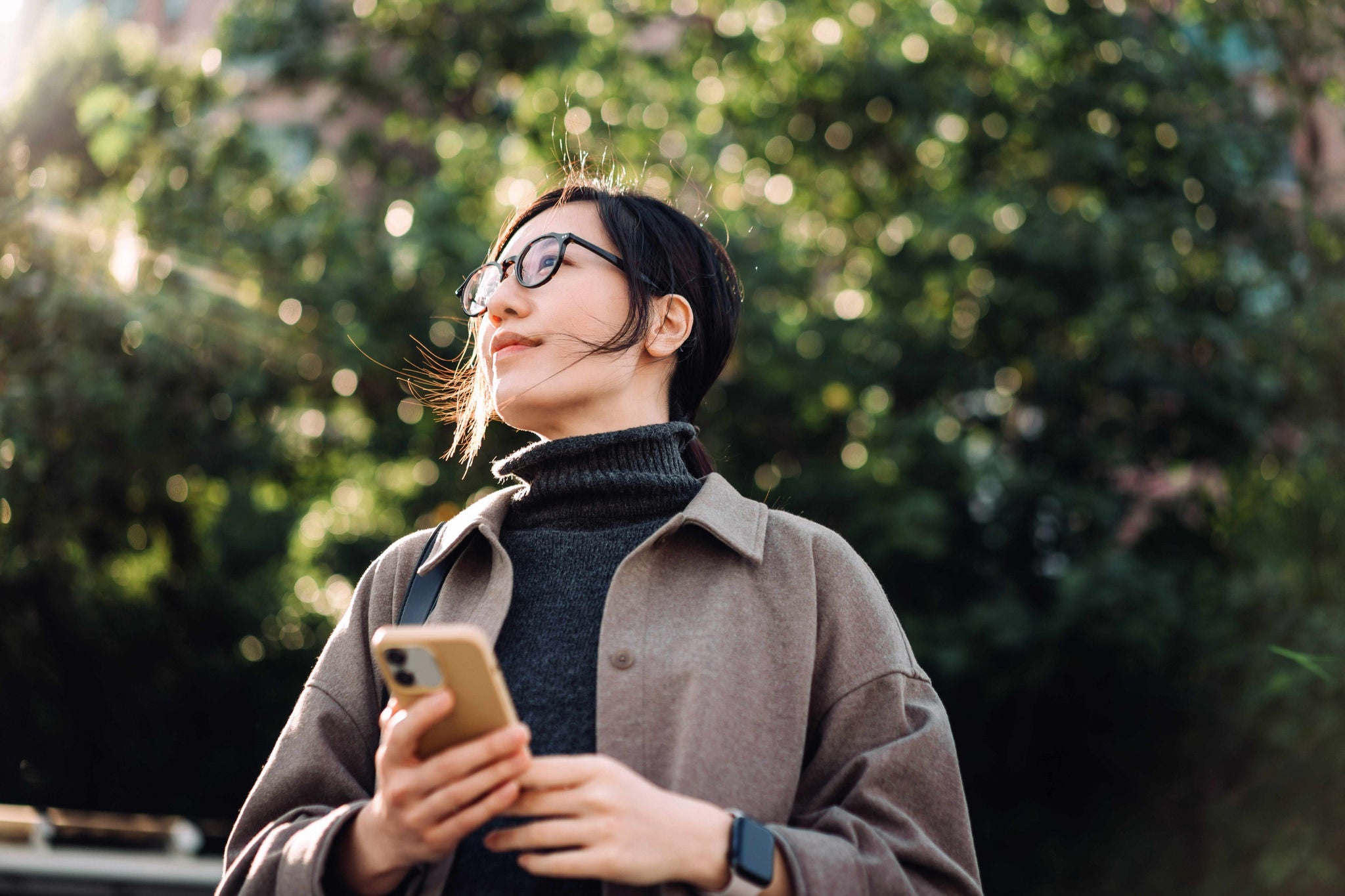 Young Asian woman using smartphone in park