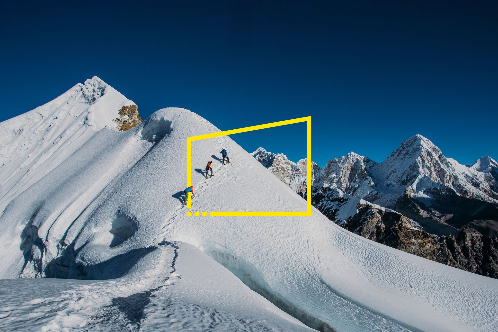 Three people climbing a mountain