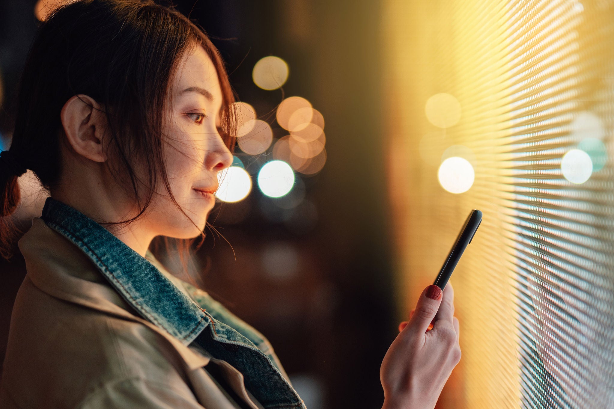 Young woman using crypto investment app on smart phone