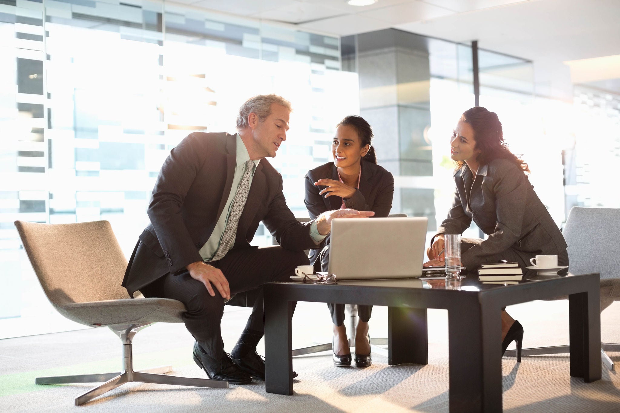 Business people with laptop meeting in lobby