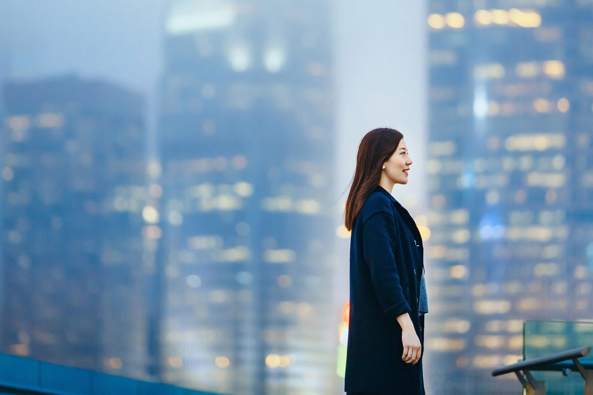 自信的女商人笑脸面向夜幕下的城市