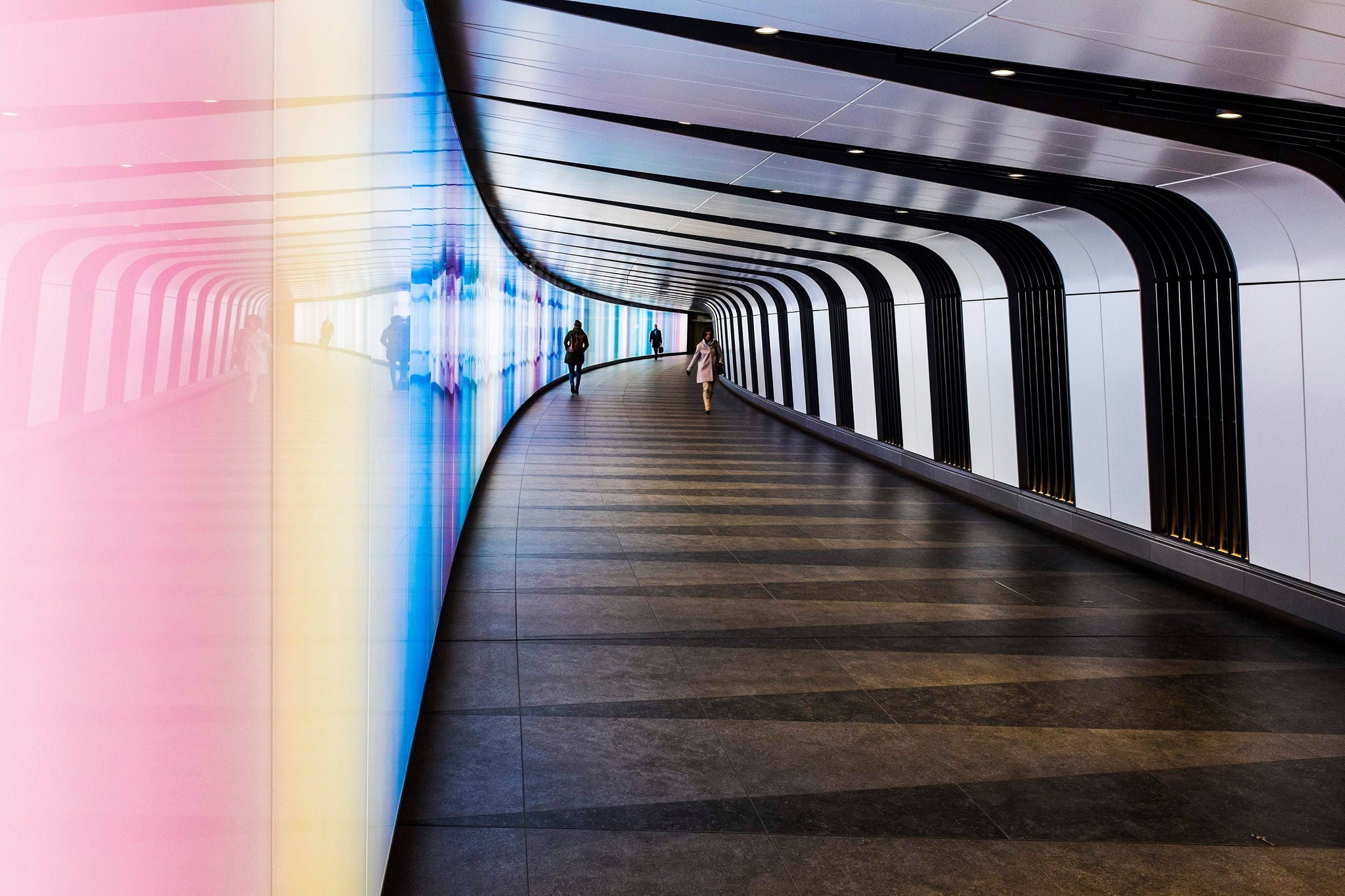 Pedestrian walkway underground in Central London where the walls change colours every few seconds