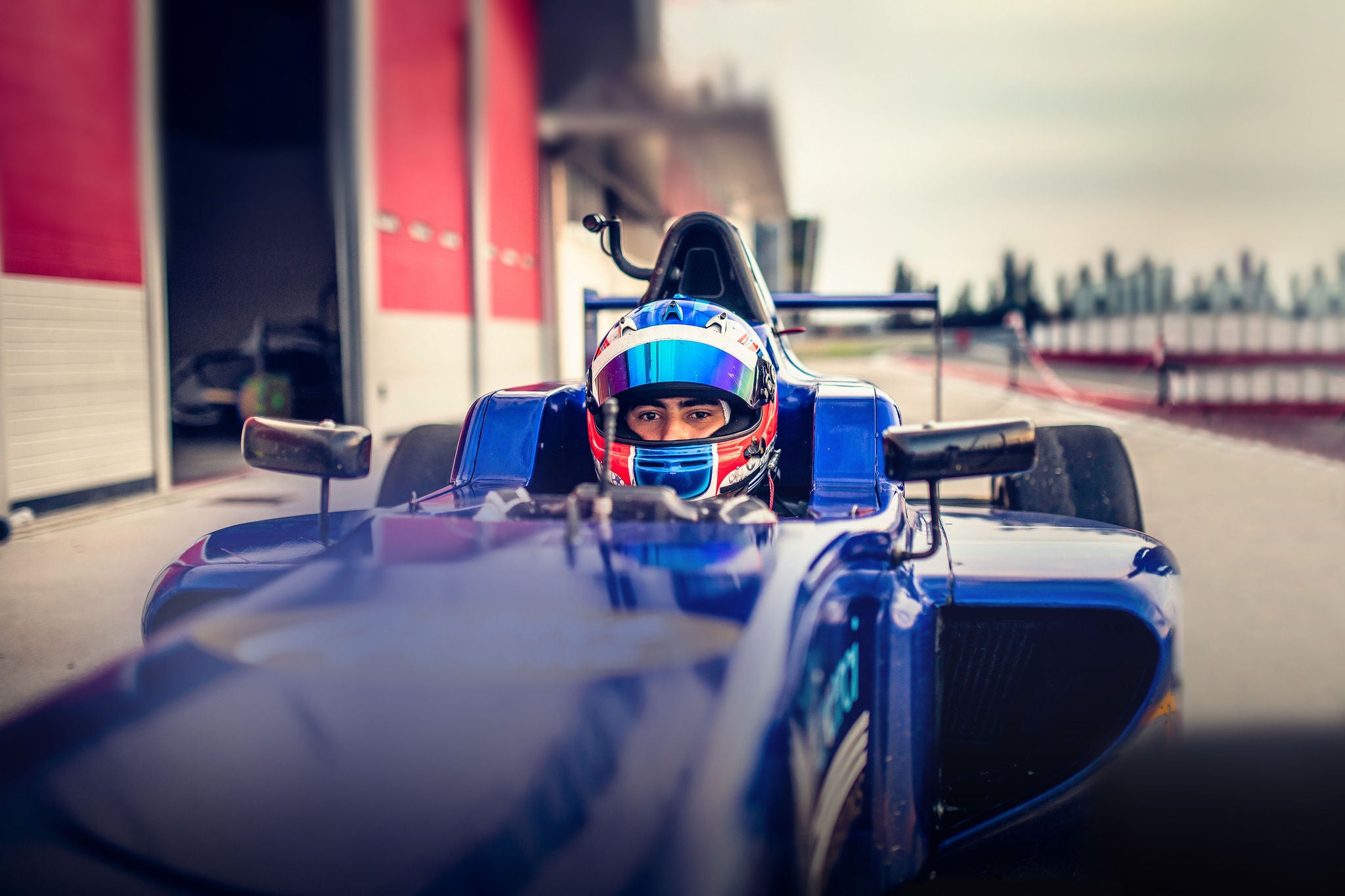 Man driving formula racing car on motor racing track