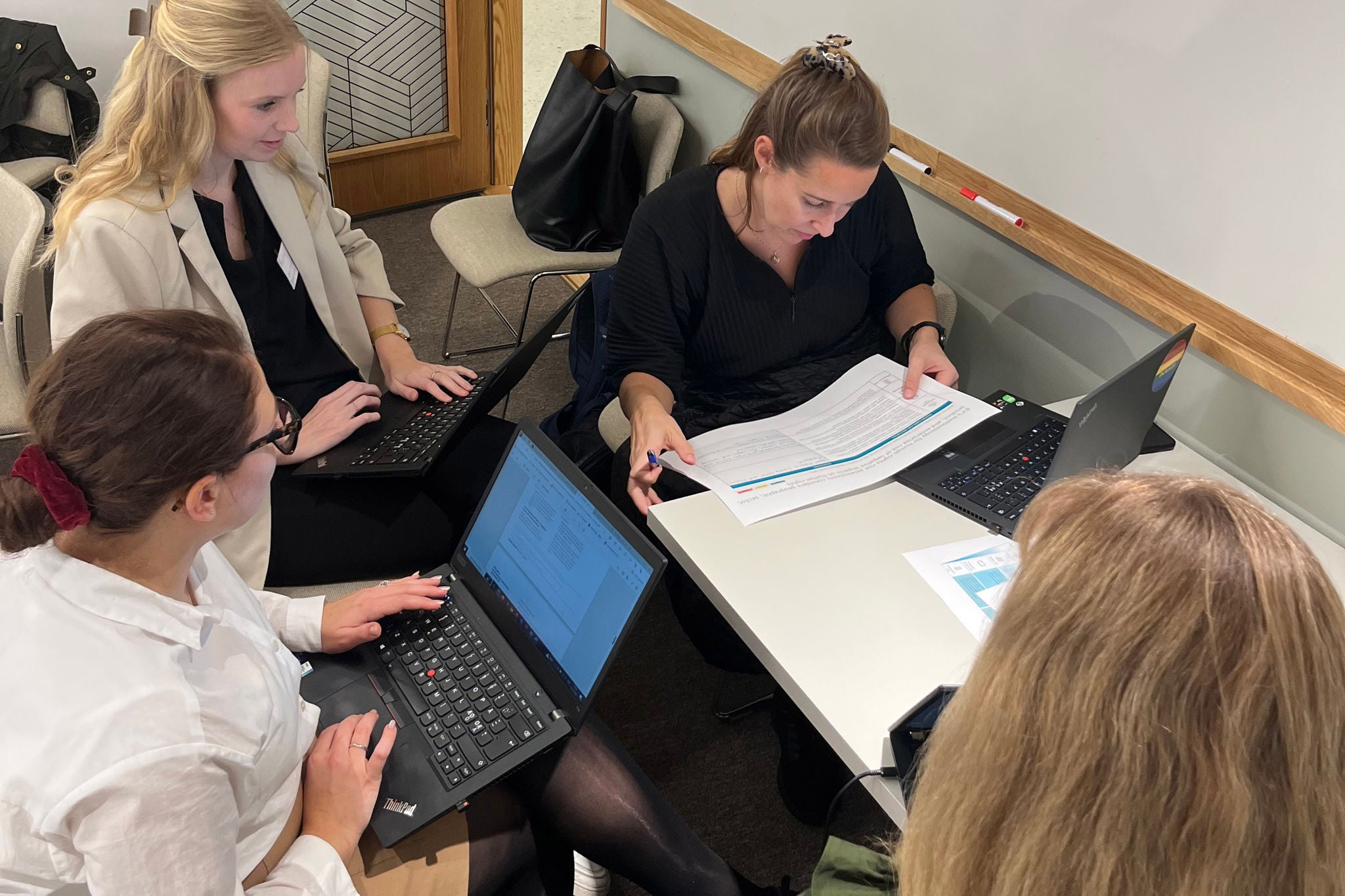 A group of people sitting at a table with a laptop