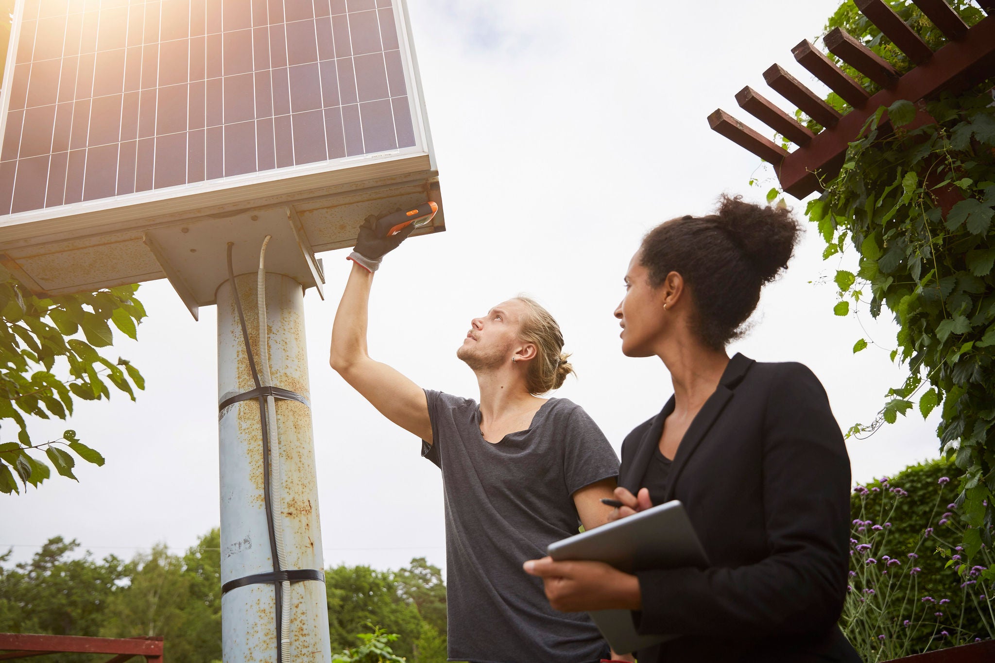 Low angle view of garden architect adjusting solar panel by colleague holding tablet computerImage downloaded by Charlie Brewer at 11:32 on the 18/06/18