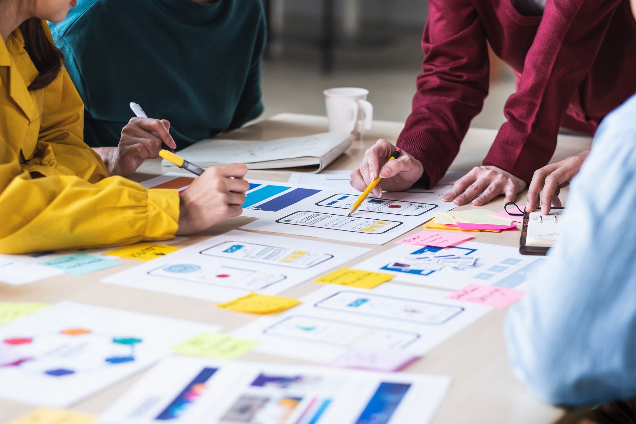 Close up ux developer and ui designer brainstorming about mobile app interface wireframe design