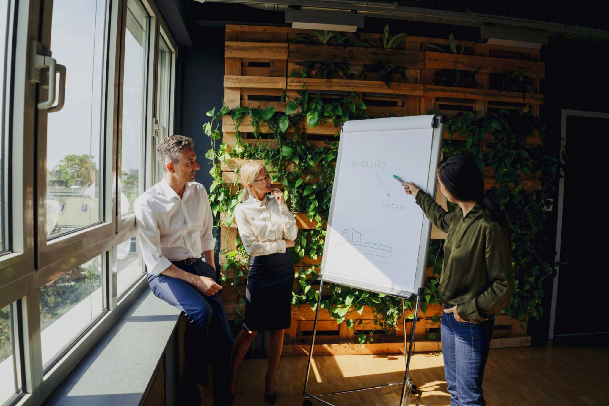 Business people working with flip chart in green office