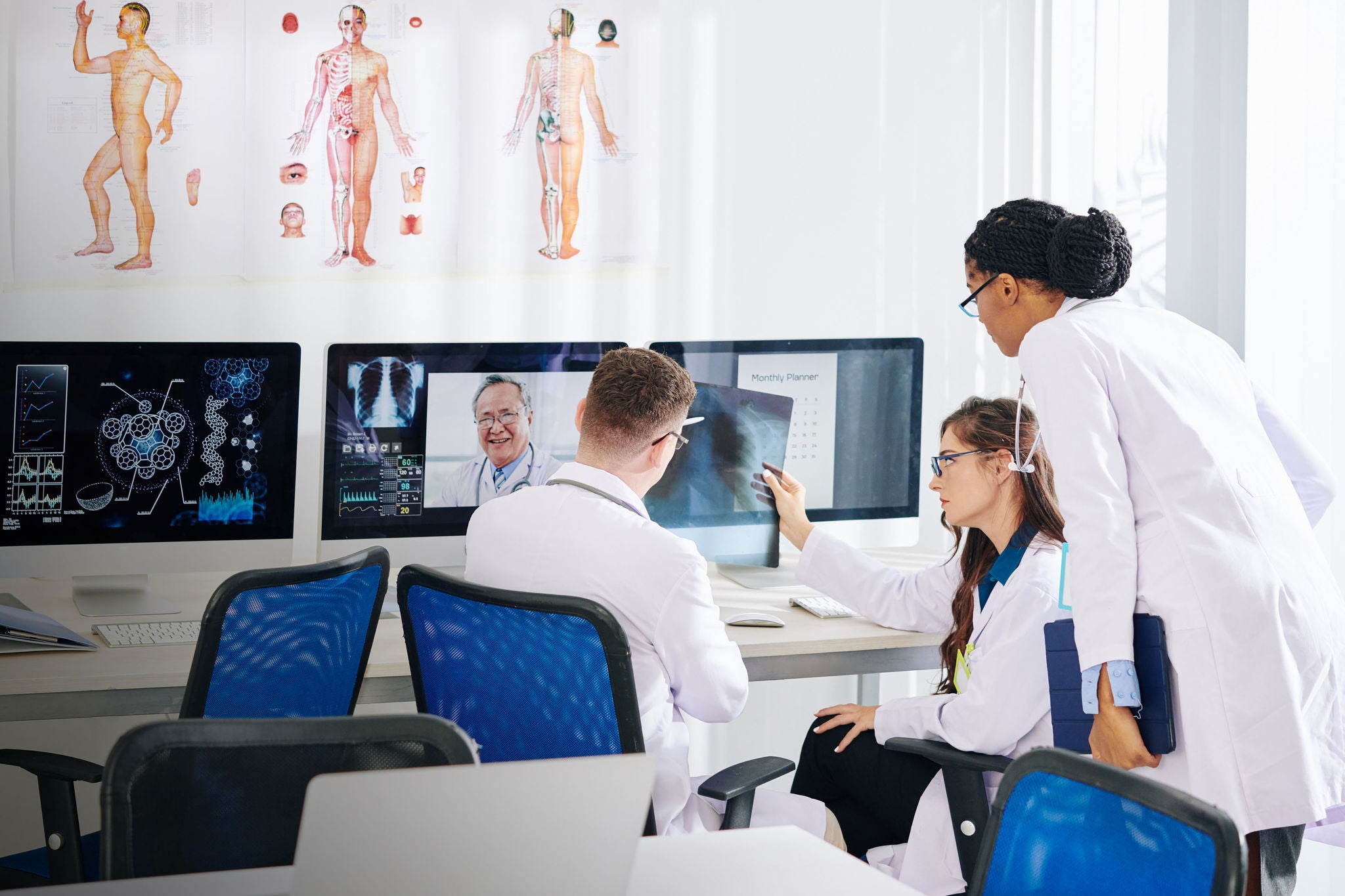 Group of medical researchers discussing lungs x-ray of patient with experienced pulmonologist