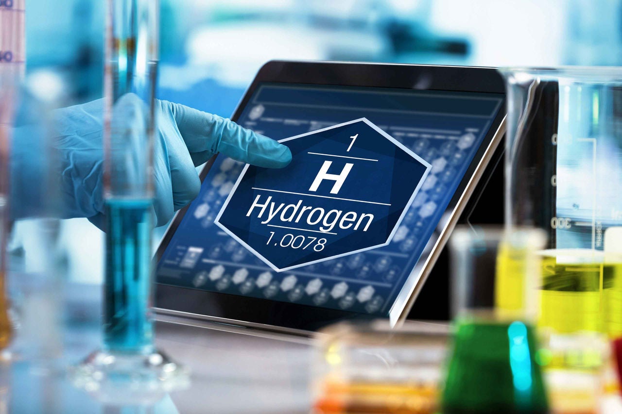 scientist consulting on the digital tablet data of the chemical element Hydrogen H