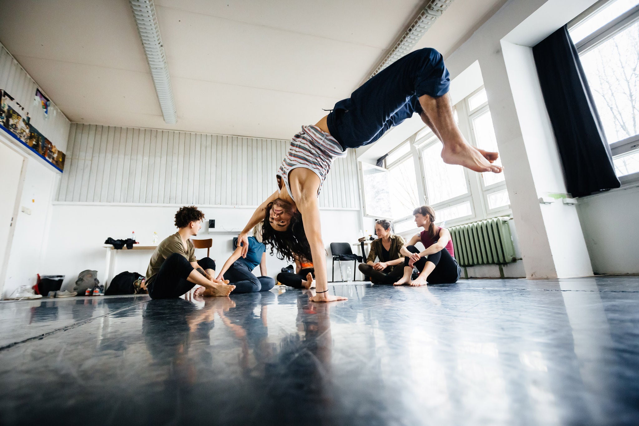 Young dancer performing in a dancing studio while the class having a break in the background