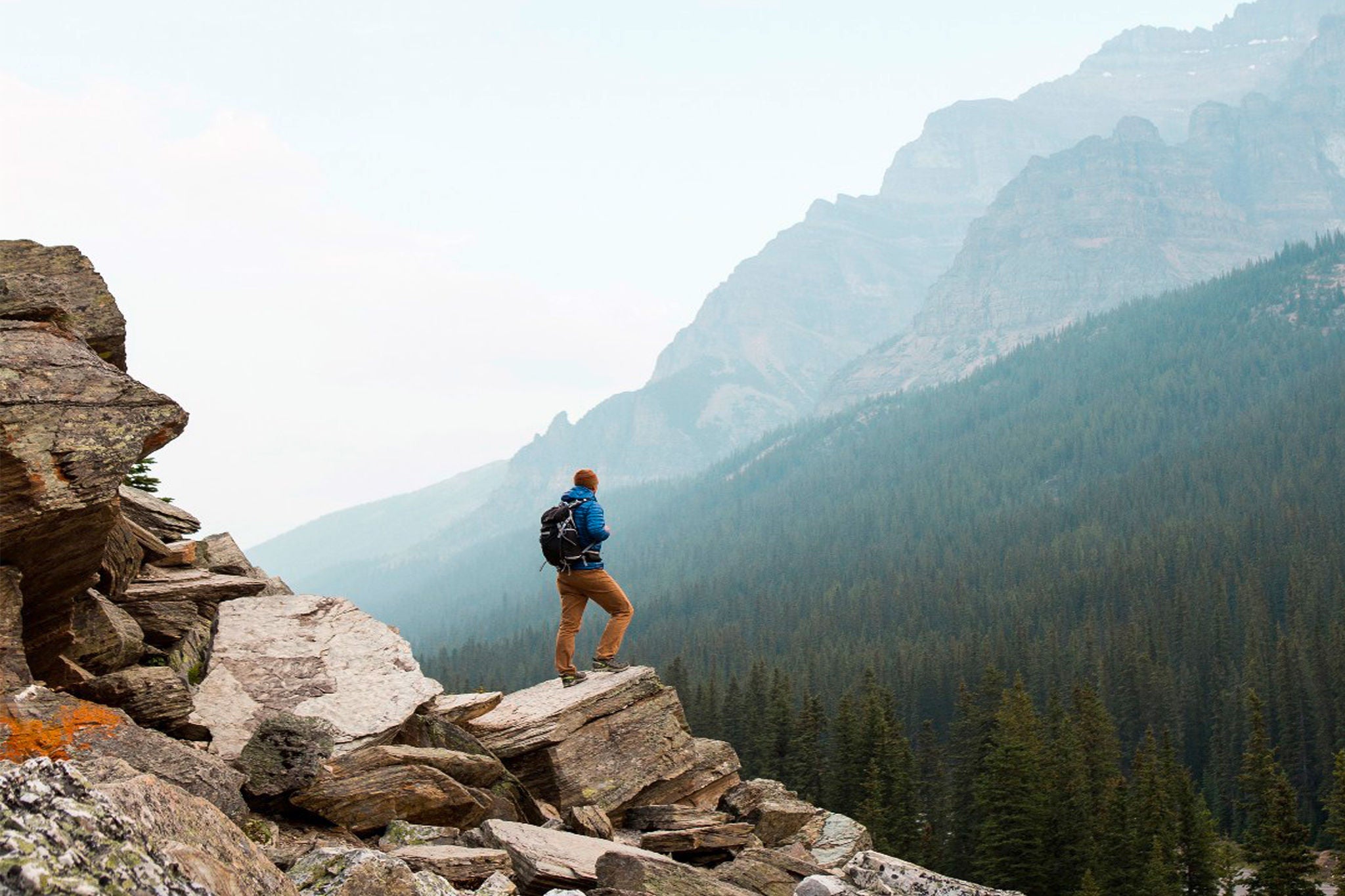 Ein Mann steht auf einem Felsen und schaut in die Weite