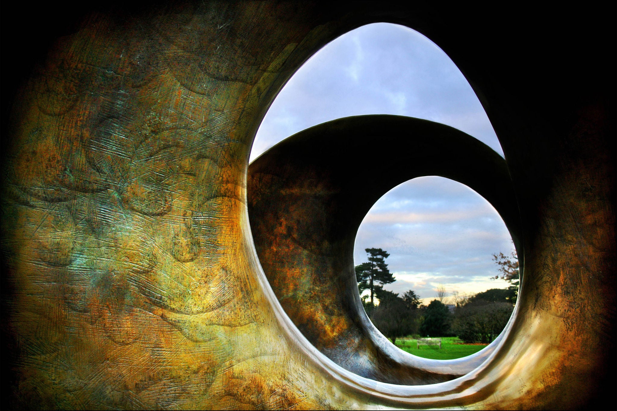 Oval skulptur med landskap i bakgrunnen