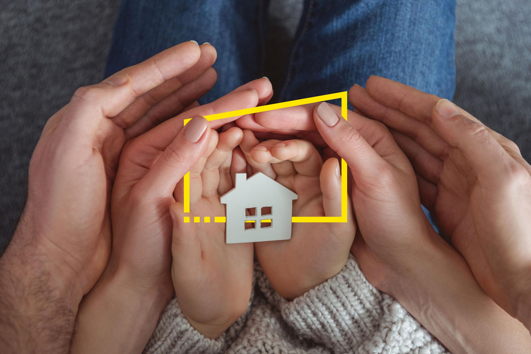 MR72C2 cropped shot of family holding small house model in hands