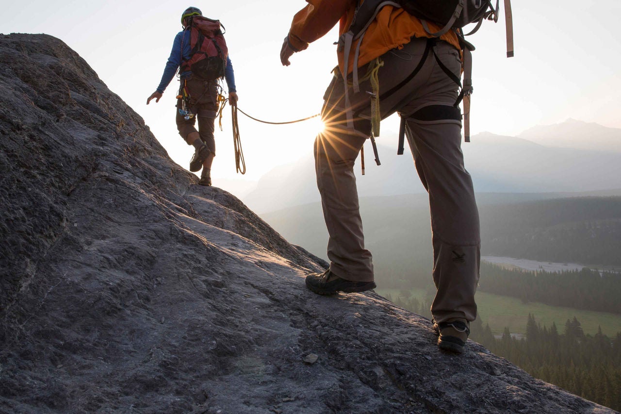 bergsteiger erklimmen einen bergkamm, sonnenaufgang