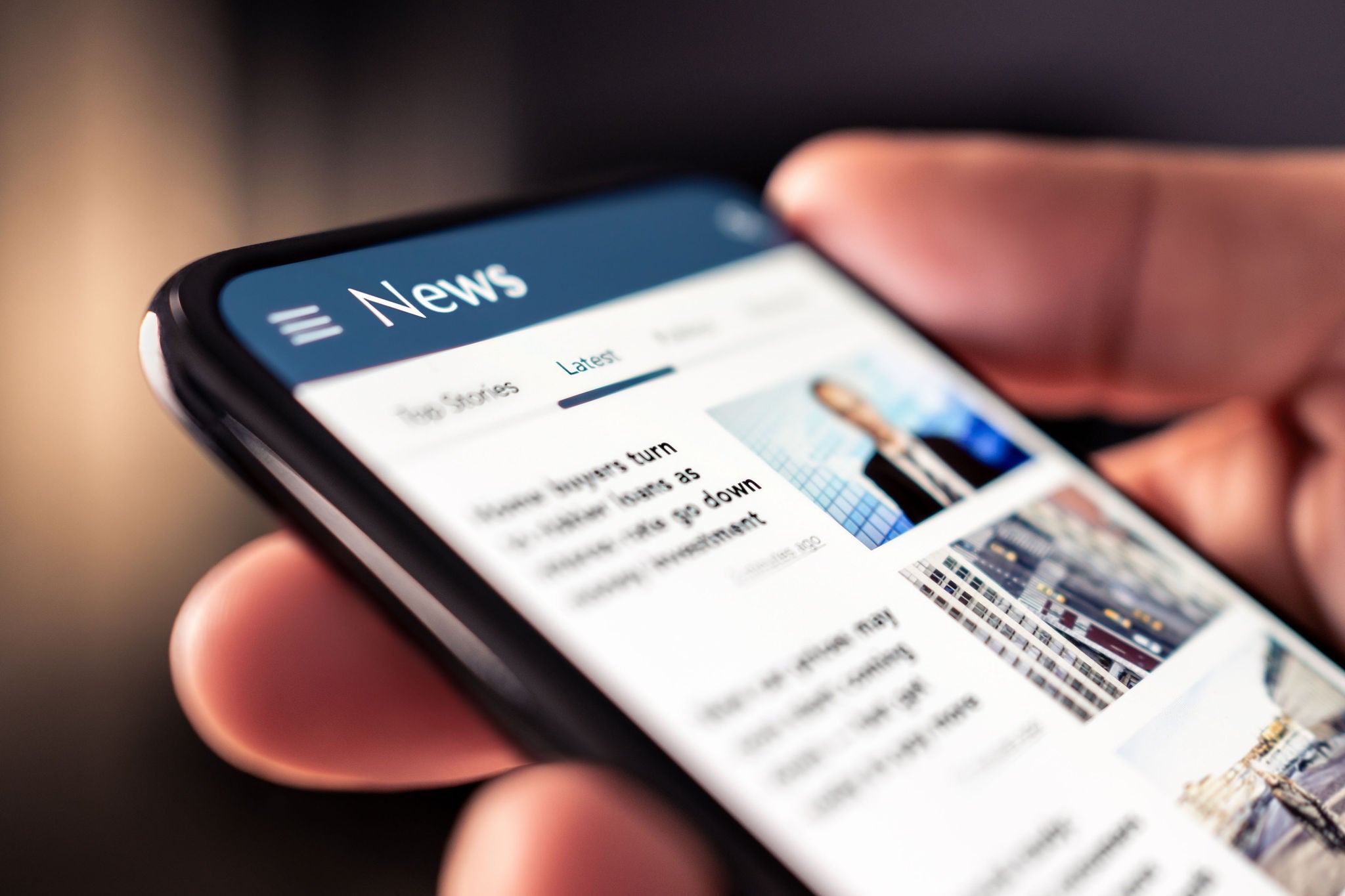 Close up shot of hand holding phone showing a news website news online on phone