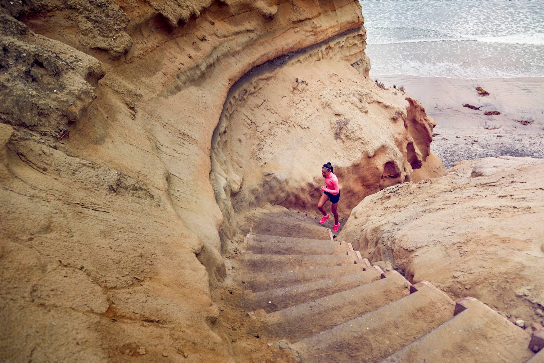 ey-teenage-girl-running-up-steps-by-beach