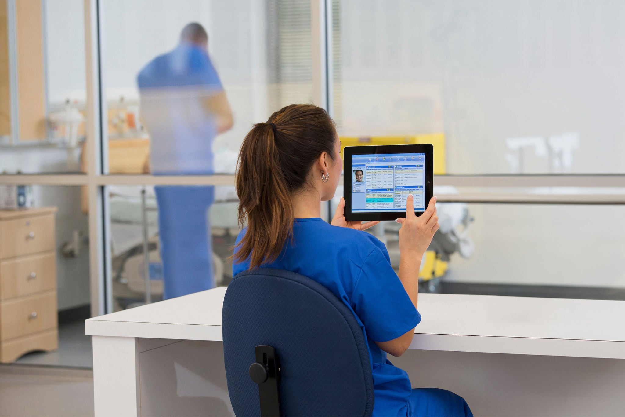 Mixed race nurse using digital tablet in hospital