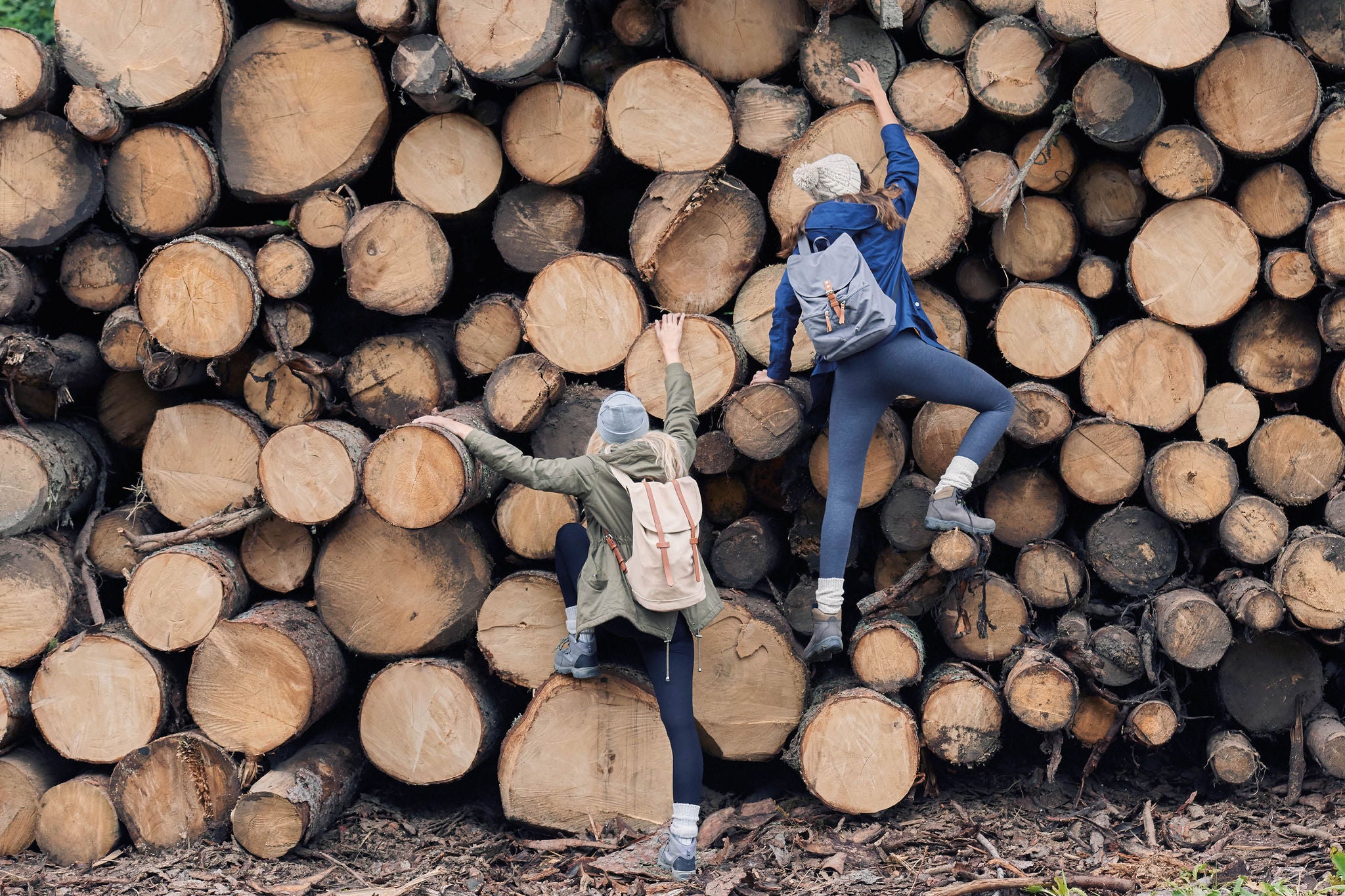 Parthenon careers 05 adventure girl friends having fun climbing up wood pile in forest