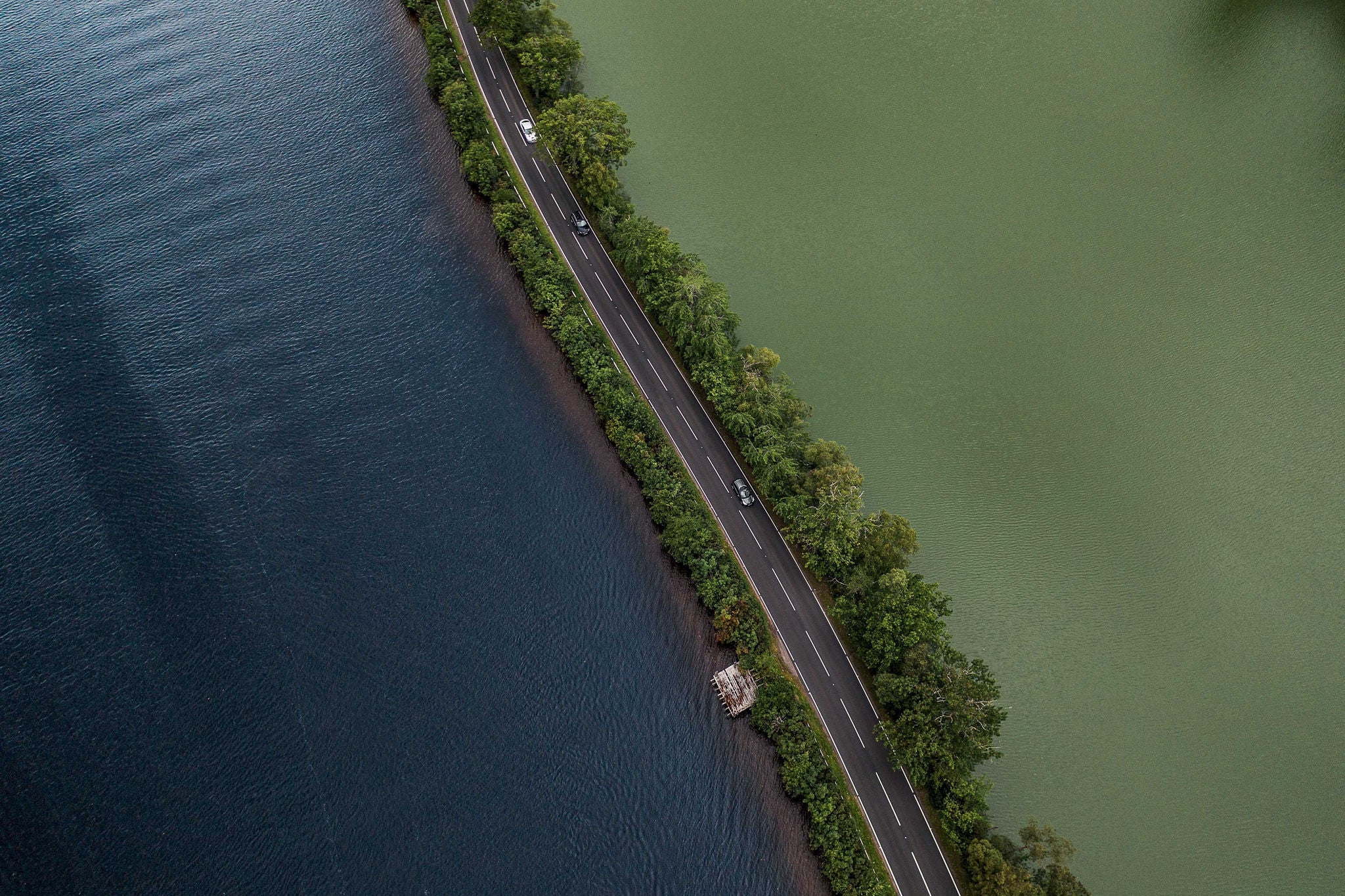 Road crossing two lakes photographed by drone