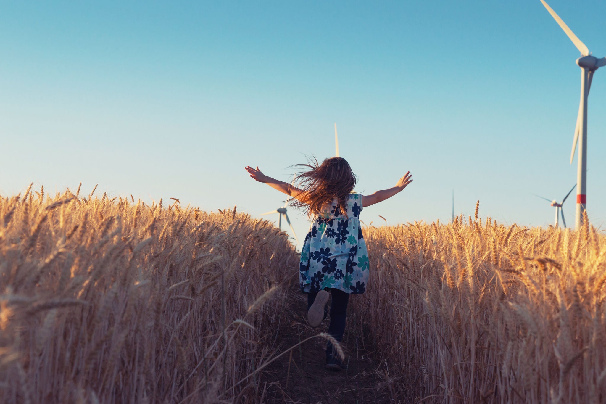 Girl is running the way to wind energy