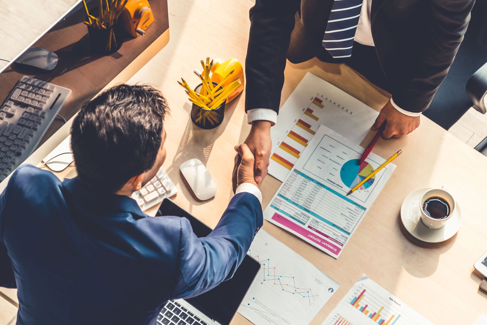 Group business people handshake at meeting table in office together with confident shot from top view . Young businessman and businesswoman workers express agreement of investment deal.