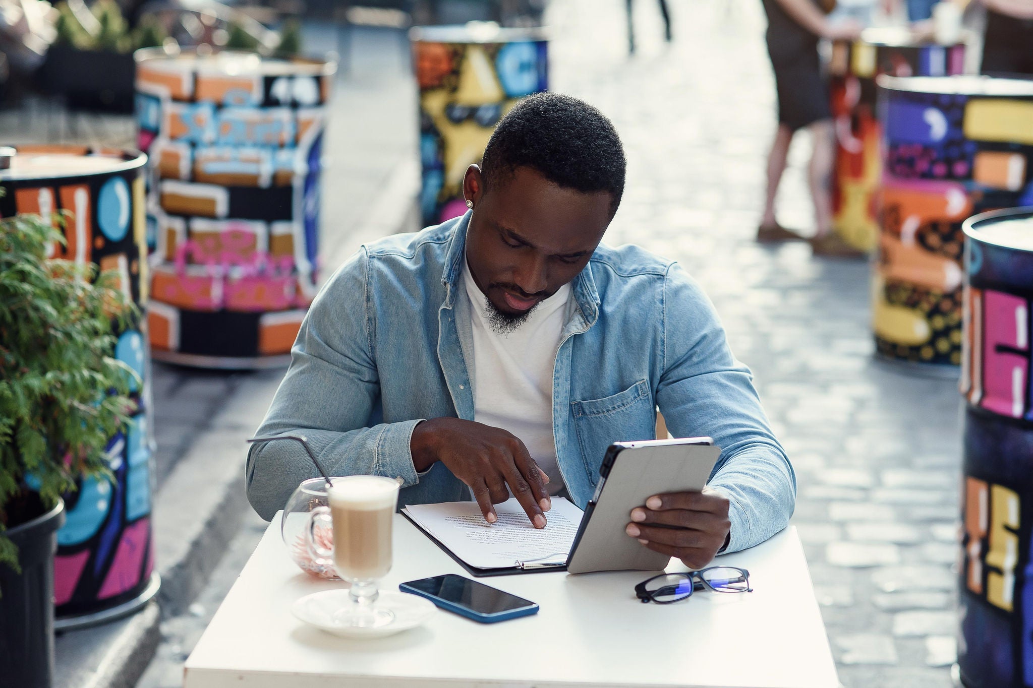 EY – Homme lisant un document papier et travaillant sur un ordinateur portable