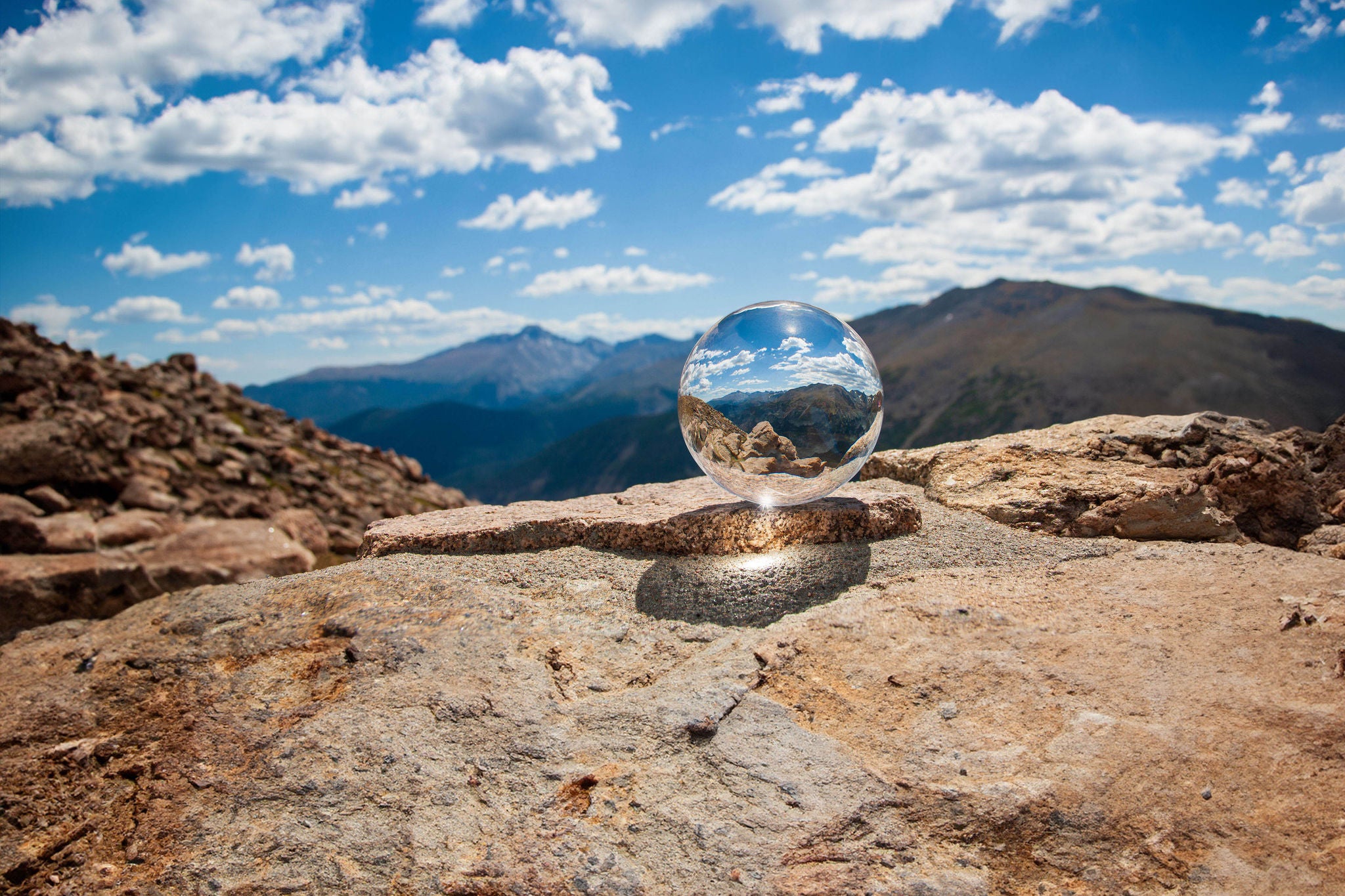 Glass ball sitting on a rock in the Rock Mountains.