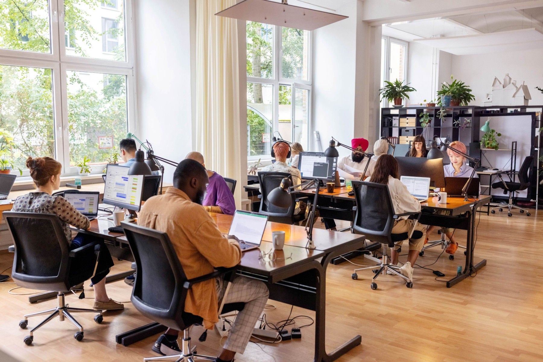 Viele junge Leute arbeite am PC in einem Büro.