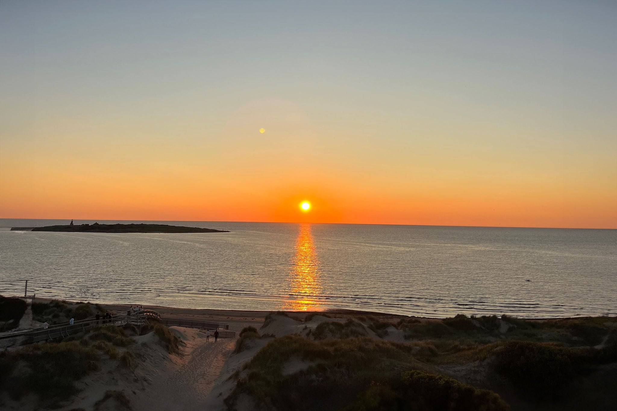 Bild på Gruppbild på glada EY kollegor framför en solnedgång vid havet