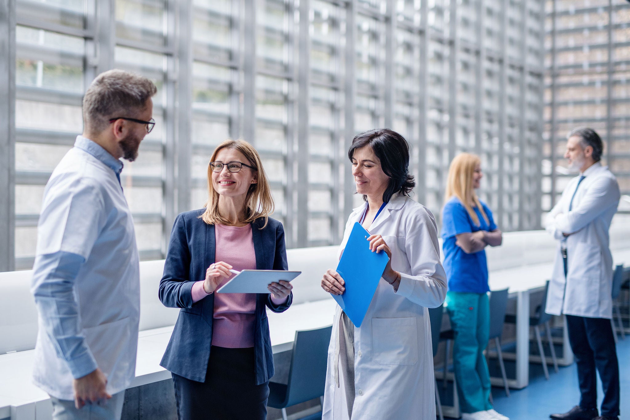 Group of doctors talking to pharmaceutical sales representative on conference.