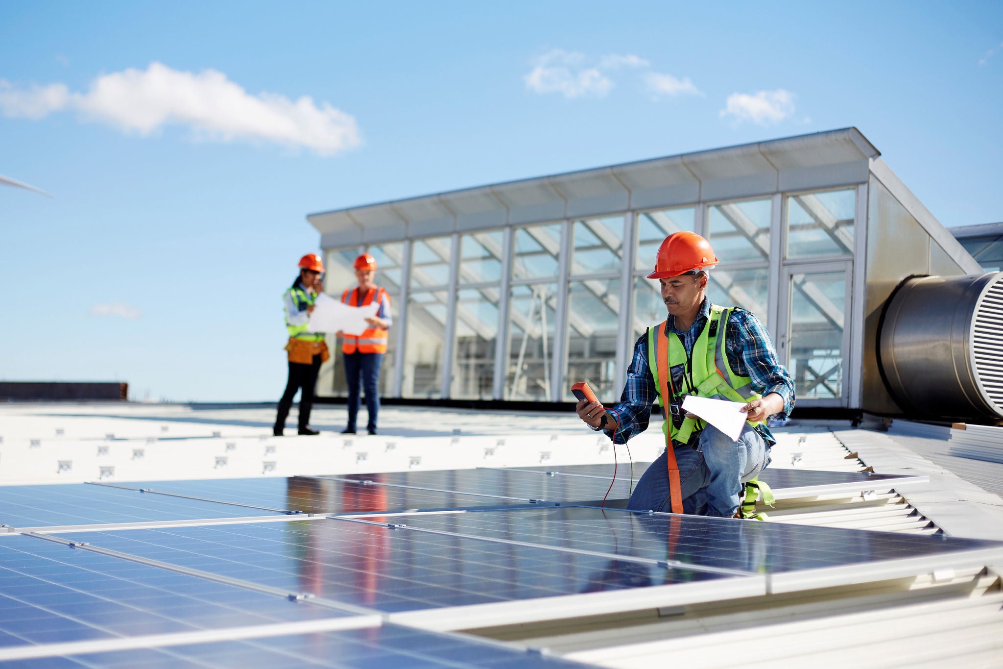 drie mensen die zonnepanelen installeren