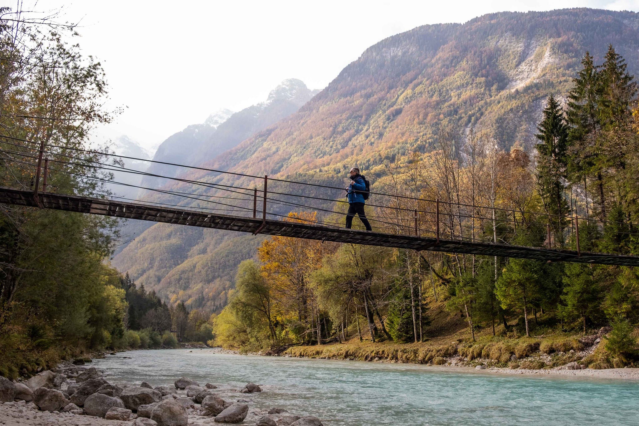 A6350; Senior Man walking on the Suspension bridge over SoÄ a River in Julian Alps, Trenta, Bovec, Slovenia, Europe.