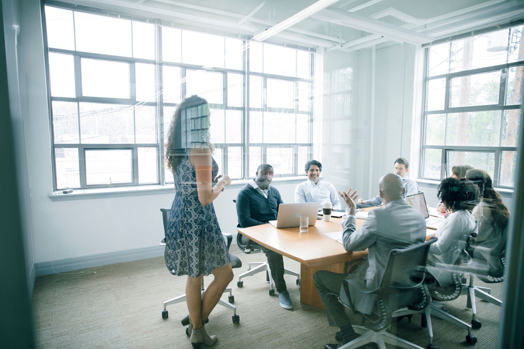 Businesswoman talking behind window in meeting