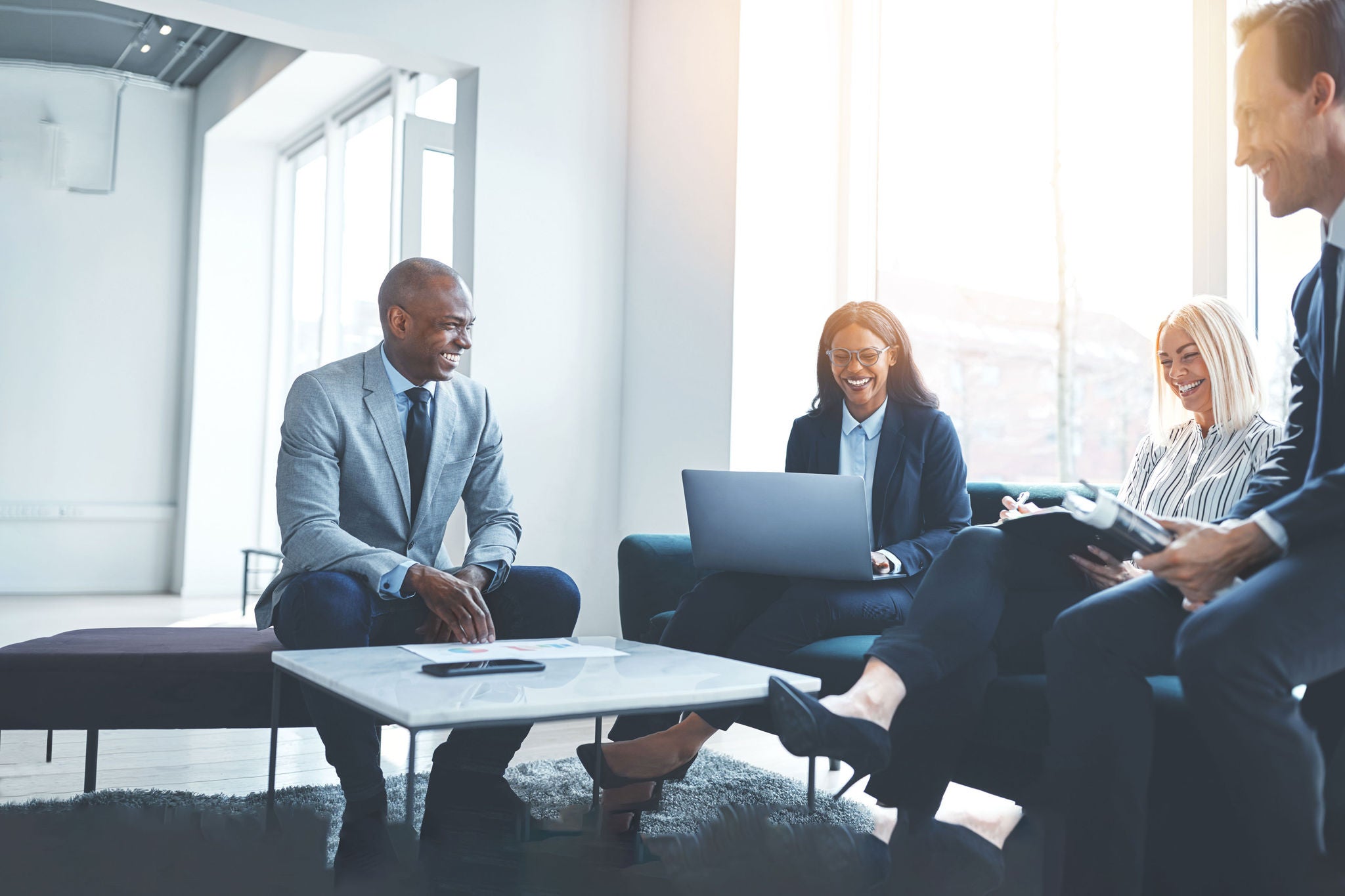 Diverse businesspeople sitting on an office sofa having a meetin