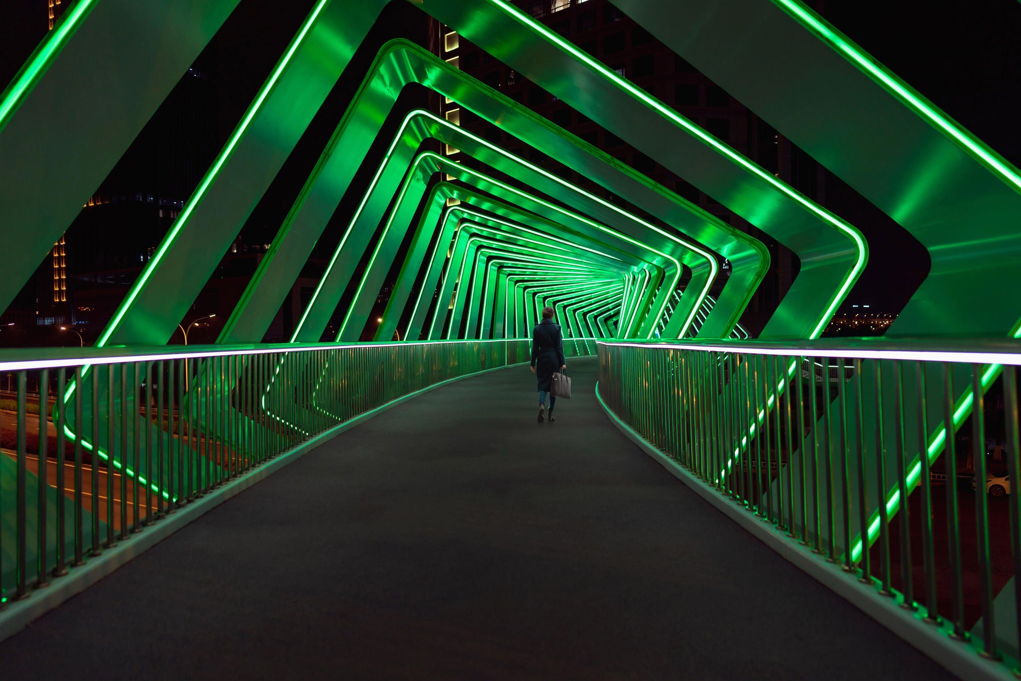 EY Mulheres atravessando uma ponte para pedestres com efeitos de luz