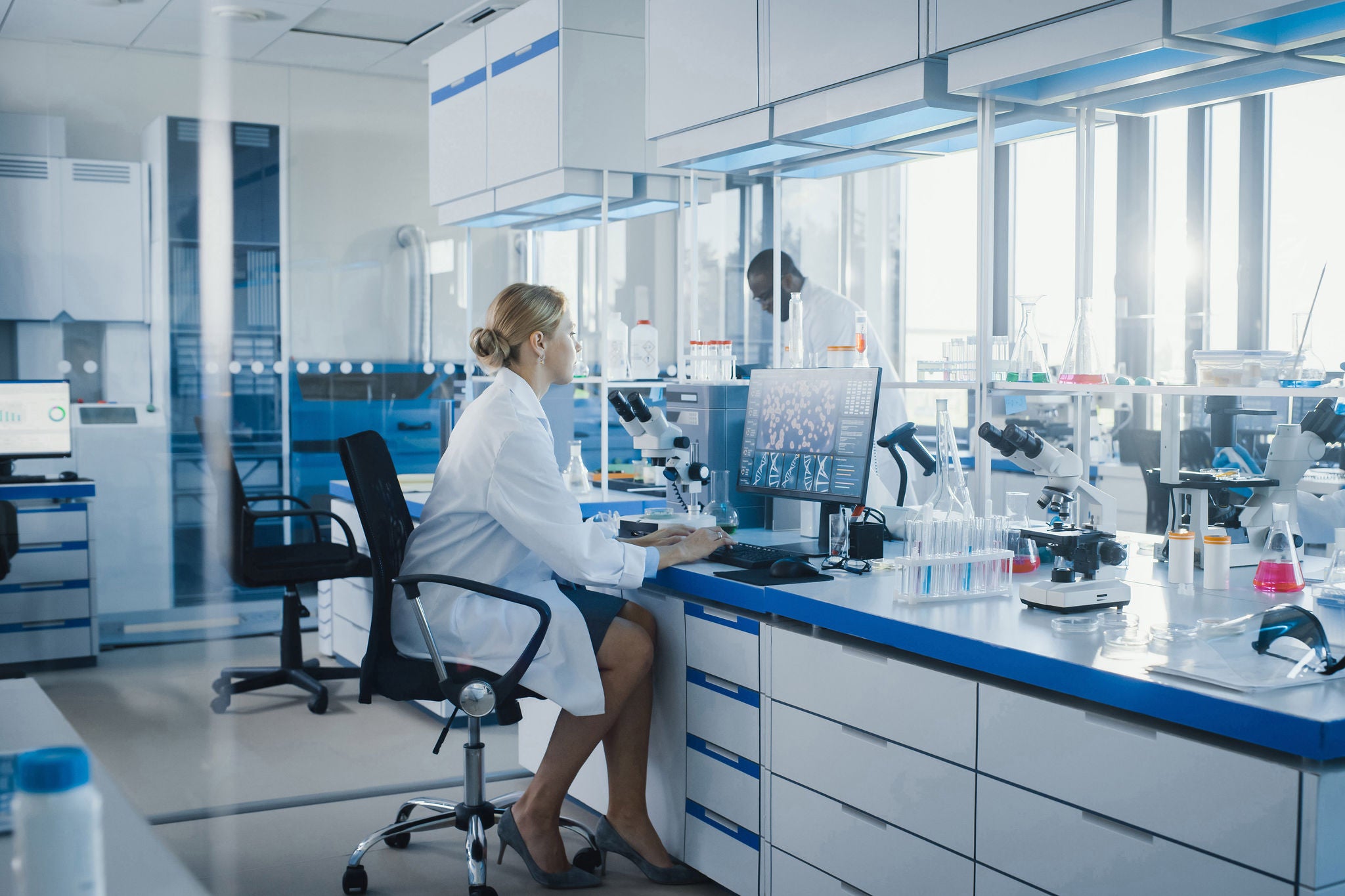 ey-female-scientist-with-microscope-and-computer