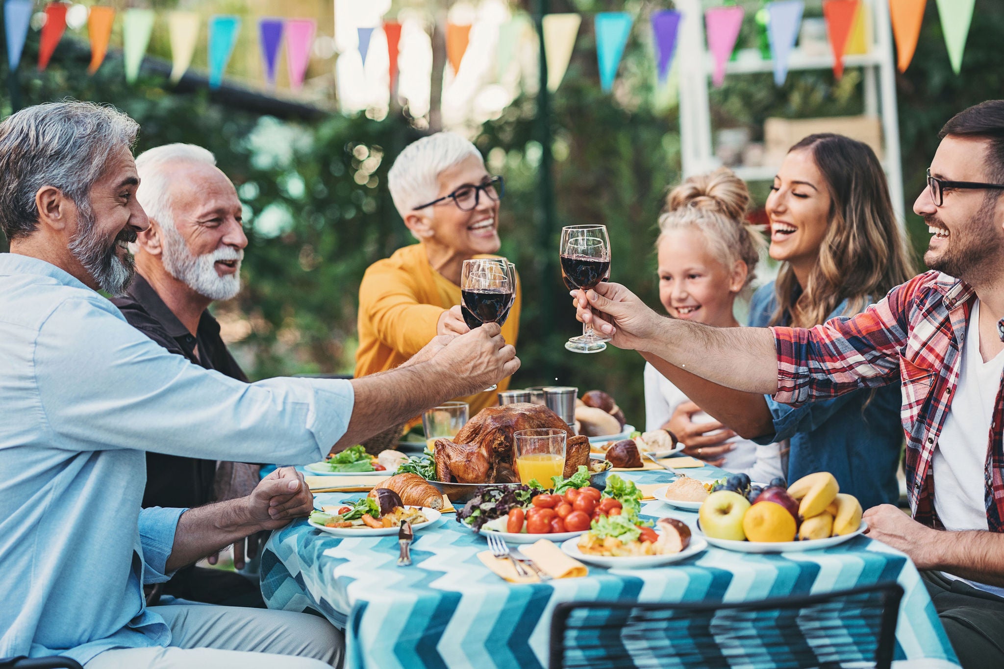 Foto af Familie løfter glas til en skål ved middag