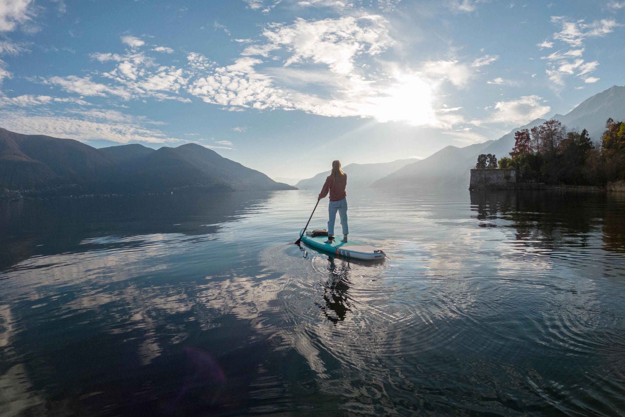 frau paddelt auf einem stand up paddle board