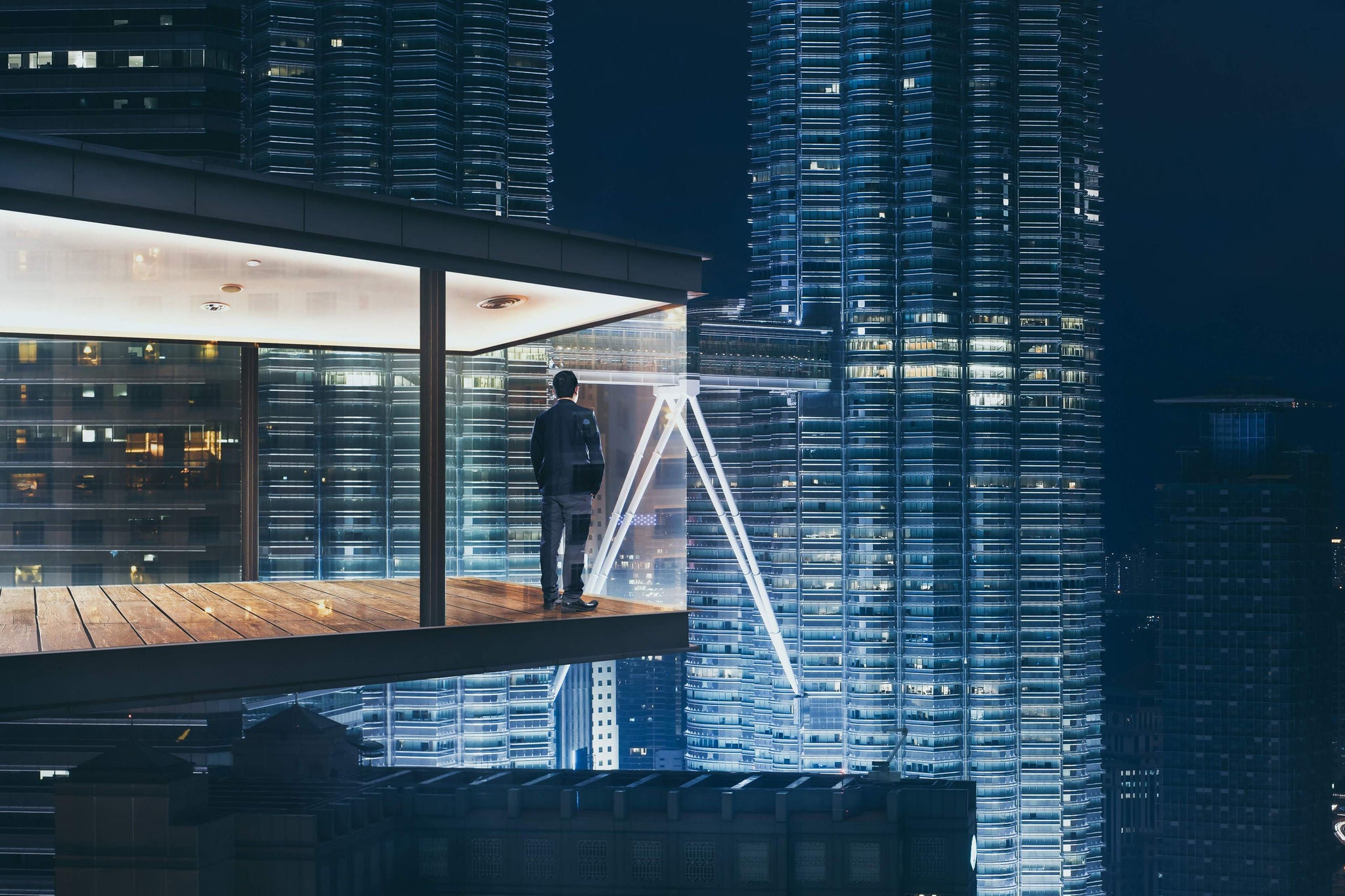 Businessman in an modern sky office by night with beautiful city skyline view .