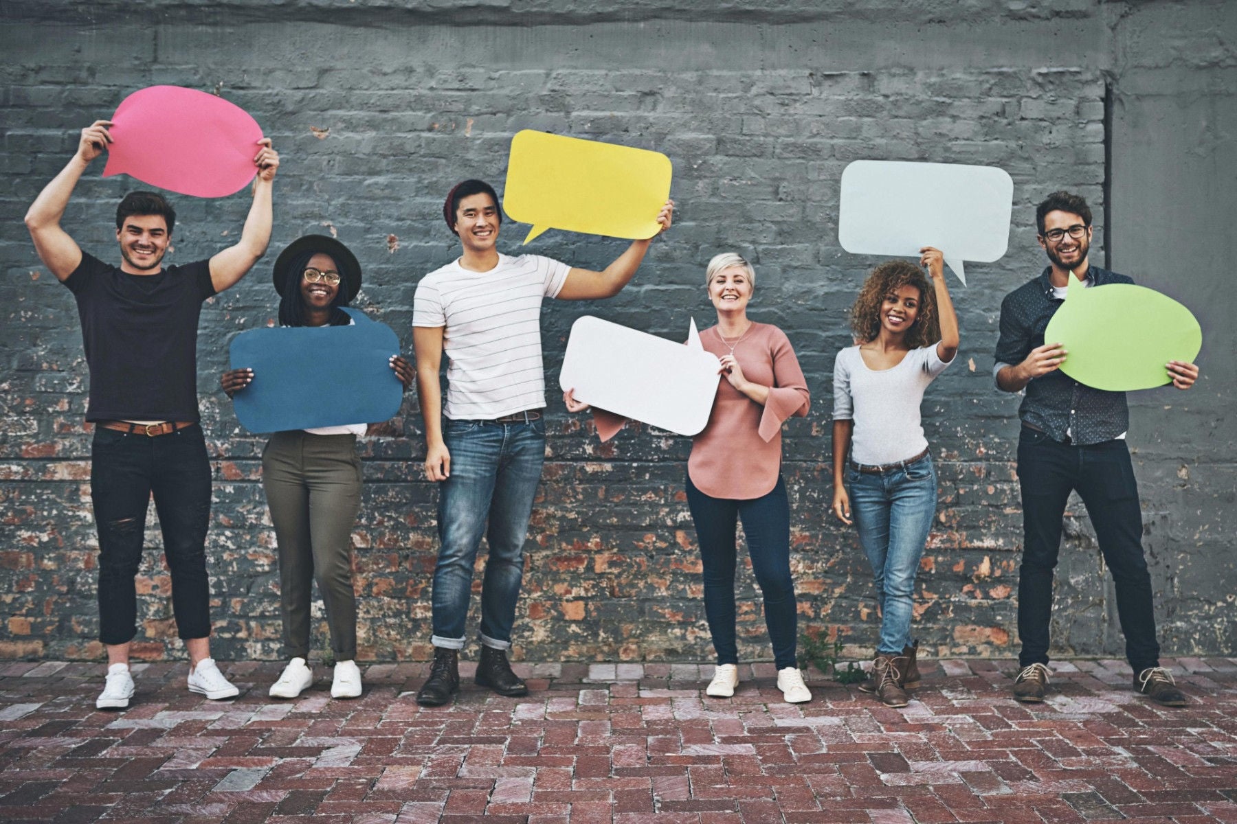 Diverse group of people holding up speech bubbles