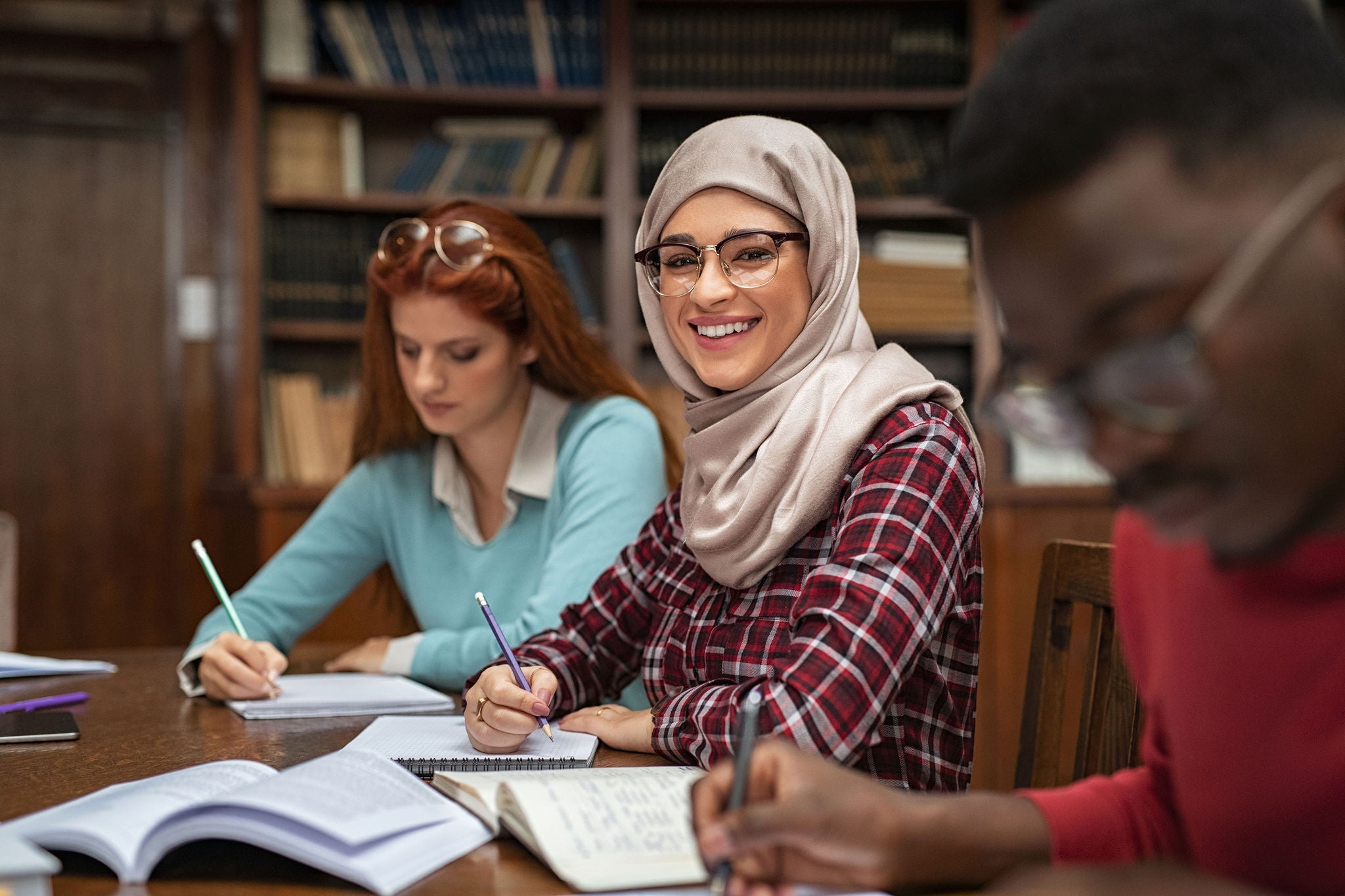 Islamic girl studying with multiethnic students