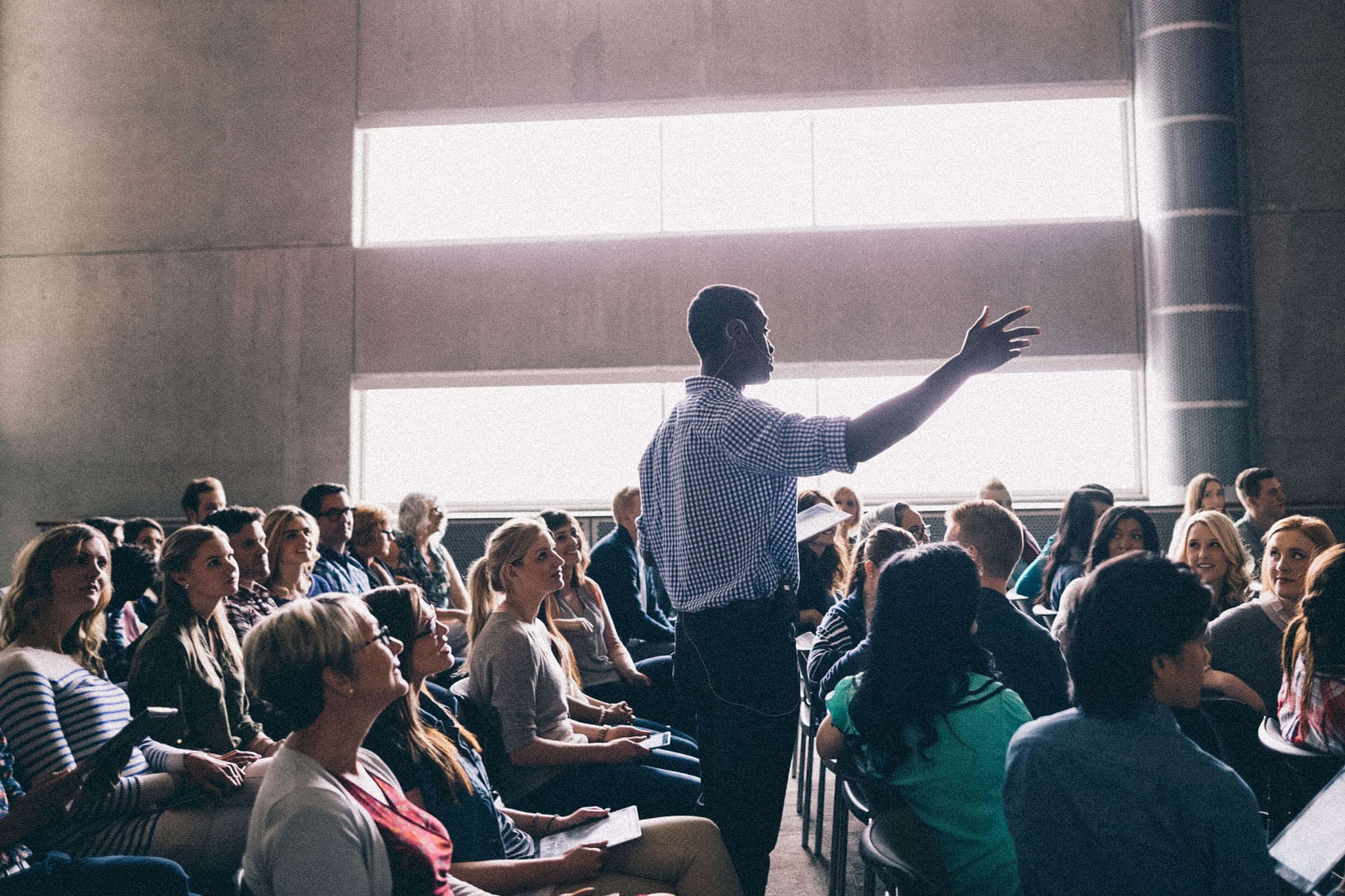 A man talking to an audience at a conference