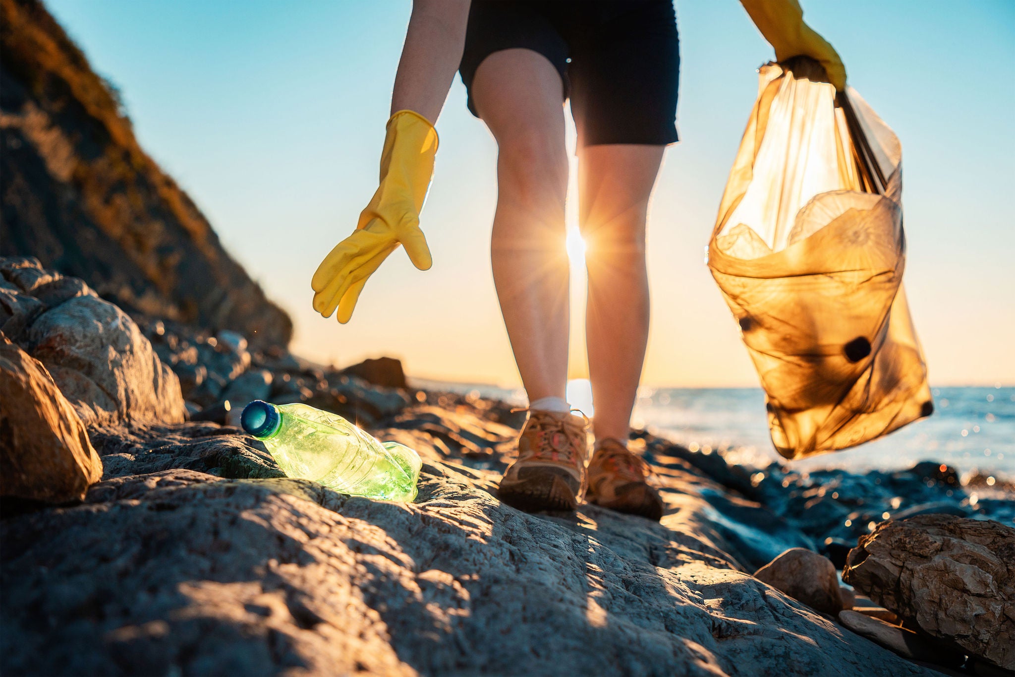 Person som plockar skräp i en plastpåse