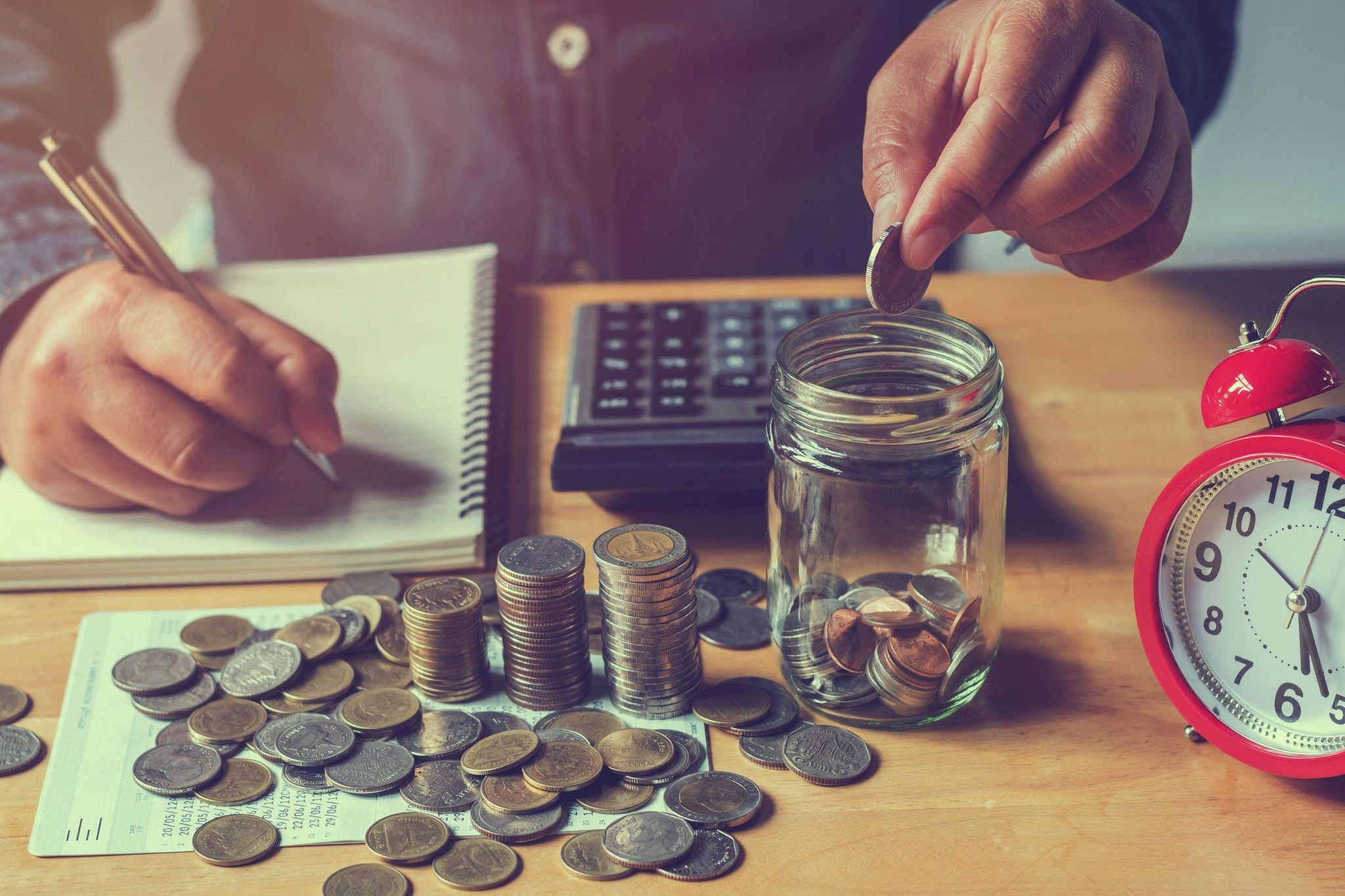 Man collecting coins while writing