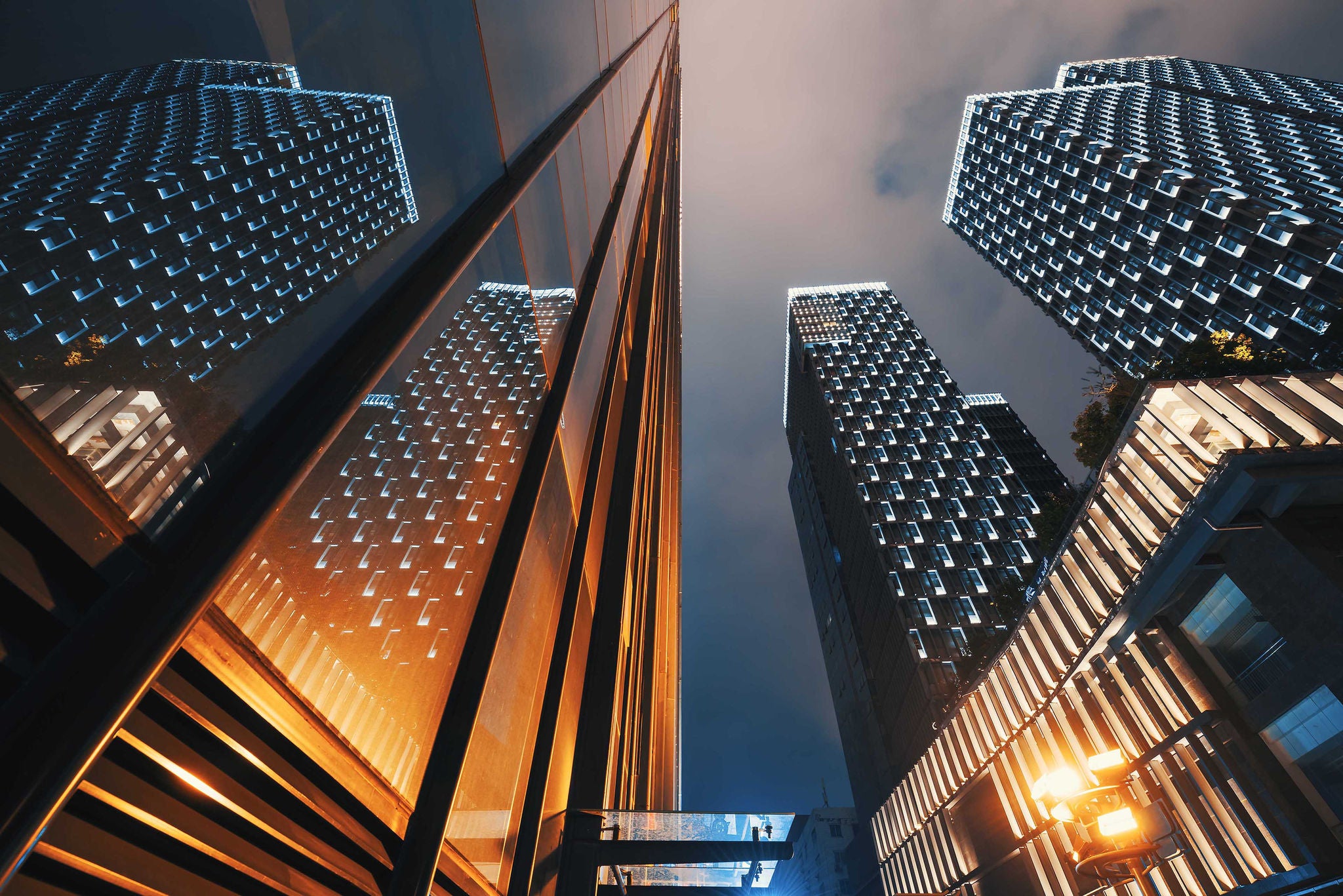 Modern skyscrapers illuminated at night reflecting on a glass facade low angle view in Chengdu, Sichuan province, China